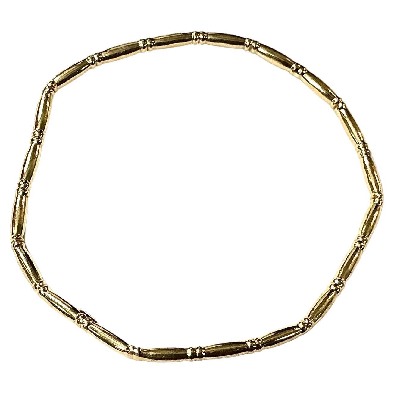 Timeless 14K Gold Bangle Bracelet designed in a bamboo-style motif. Bracelet features a seamless circular design composed of textured, rounded segments resembling natural bamboo stalks, with subtle ridging at each joint. Outer bangle is