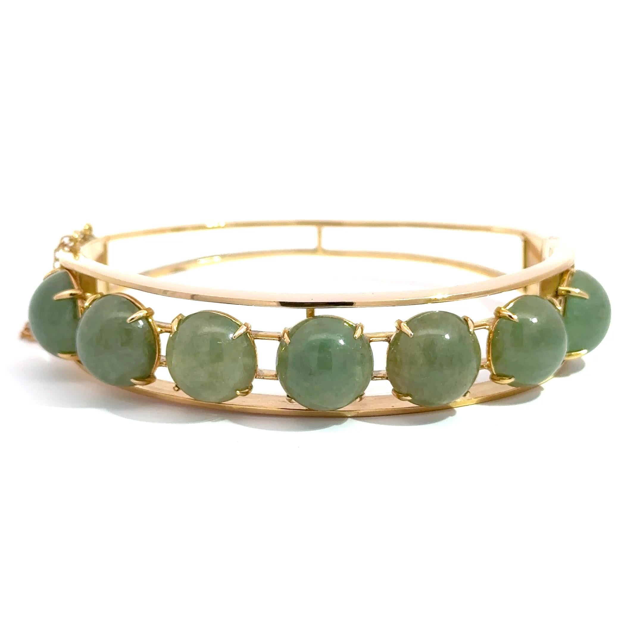 Infused with heritage and harmony, this elegant bangle features seven richly hued green jade cabochons, each bezel-set in glowing 14k yellow gold. The smooth, polished jade stones radiate serenity and balance, while the openwork frame lends the