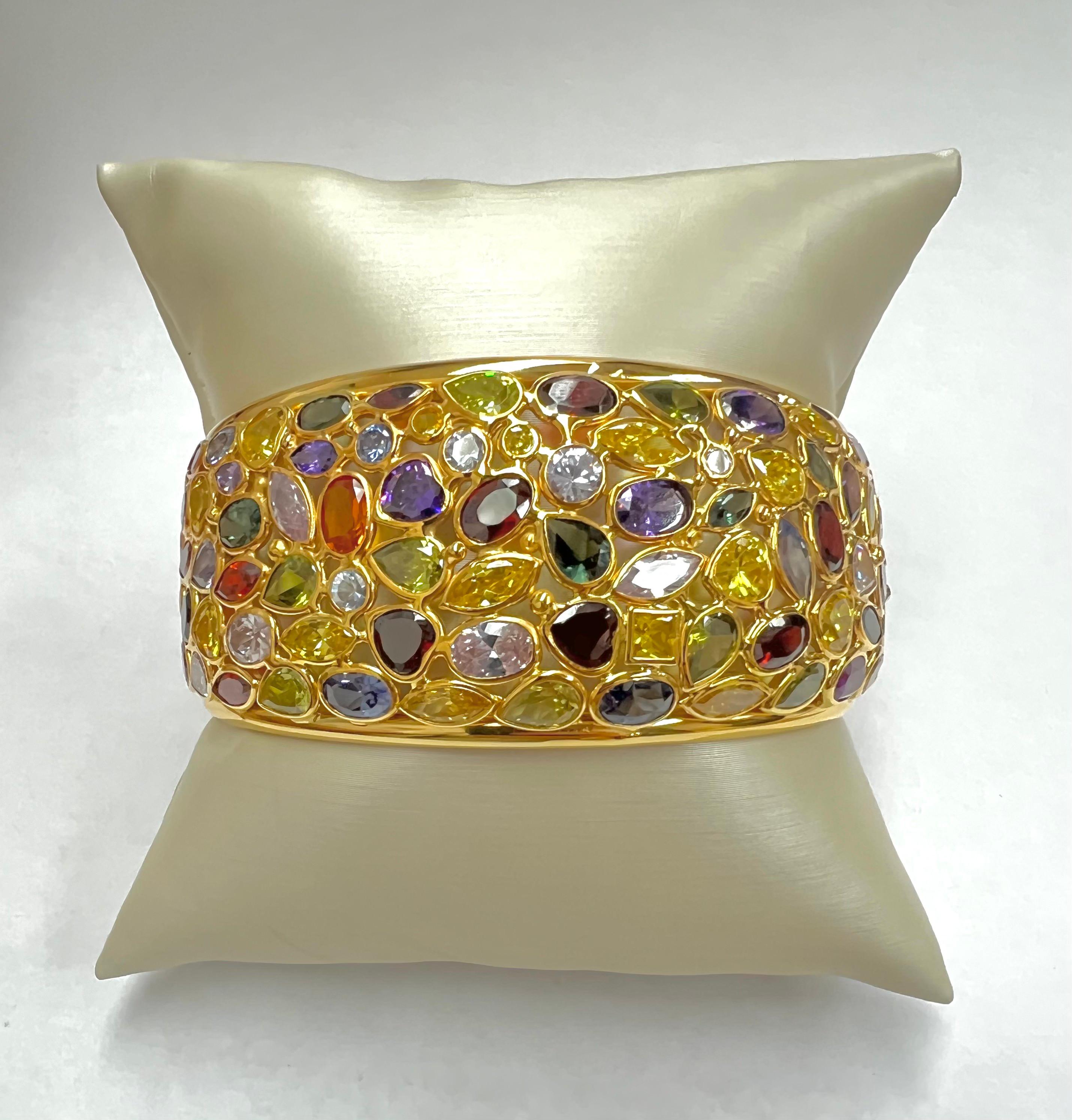 Showcasing a beautiful all natural beautiful Bangle with mixed color synthetic and sapphire stones. This is a staple piece in anyone's jewelry collection. It was carefully handmade in Los Angeles California and polished in 14k yellow gold. The