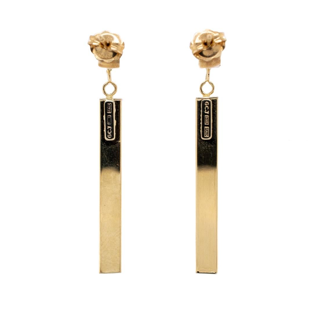 One pair of lady's custom made polished 14K yellow gold, drop earrings with push backs. The earrings are 1.98mm thick and measure approximately 1.50 inches in length by 4.08mm tapering to 3.97mm in width and weigh a total of 2.30 grams. Engraved