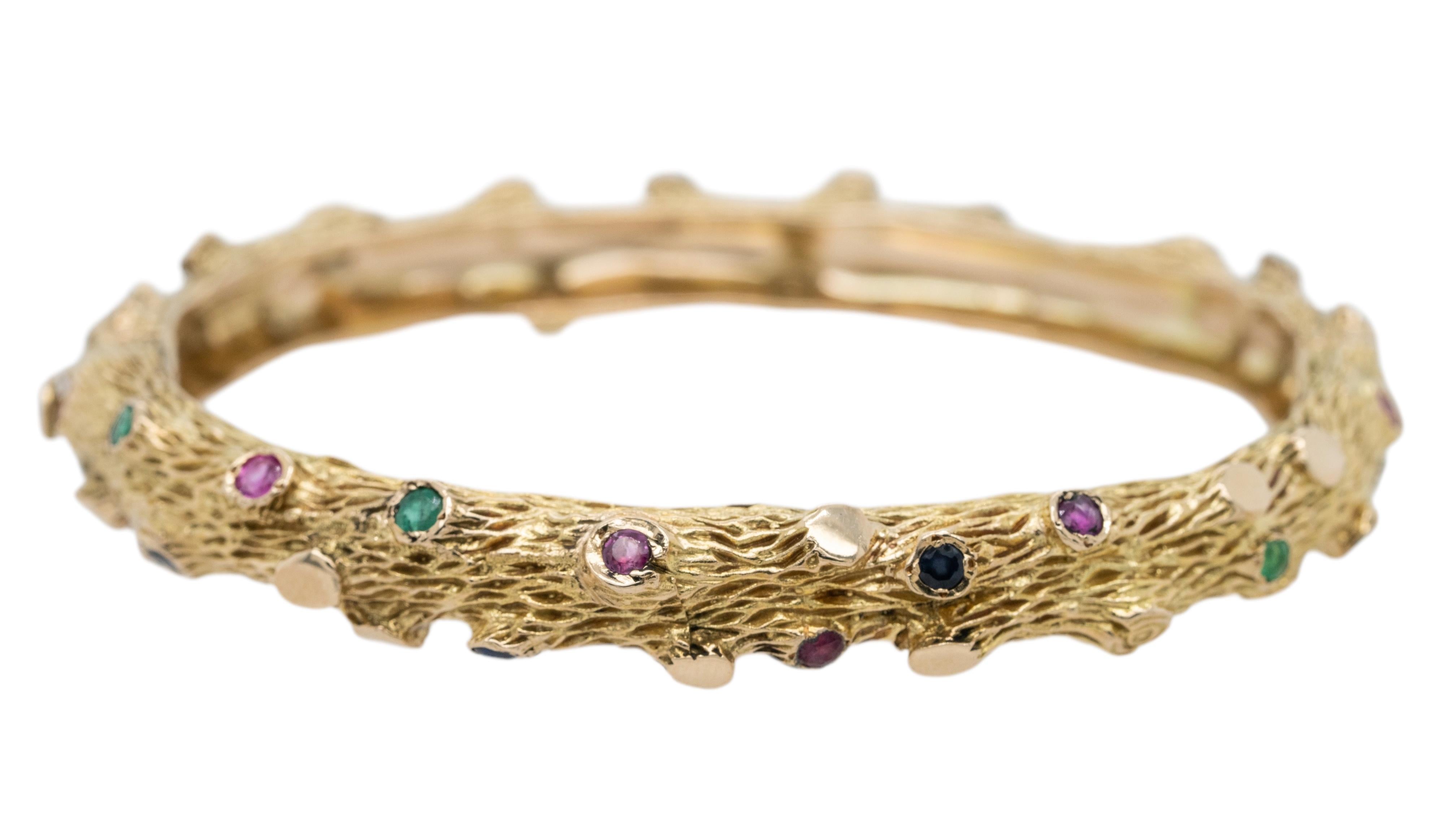 Bracelet Vintage en or jaune 14k avec émeraudes et saphirs - Un chef-d'œuvre inspiré par la Nature 

Cet exquis bracelet bangle vintage en or jaune 14k est une véritable pièce d'apparat, alliant l'élégance organique à un savoir-faire intemporel.