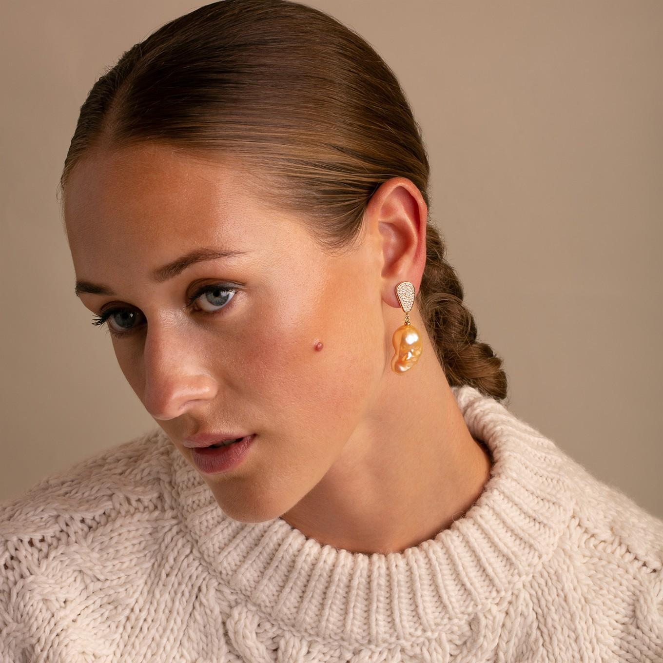 Amp up the glamour with these stunning Diamond Teardrop Natural Baroque Pearl Drop Earrings.

Featuring  hand selected  golden hued natural baroque earrings dangling from a highly polished  yellow gold Teardrop with 1.30ct of sparkling diamonds,