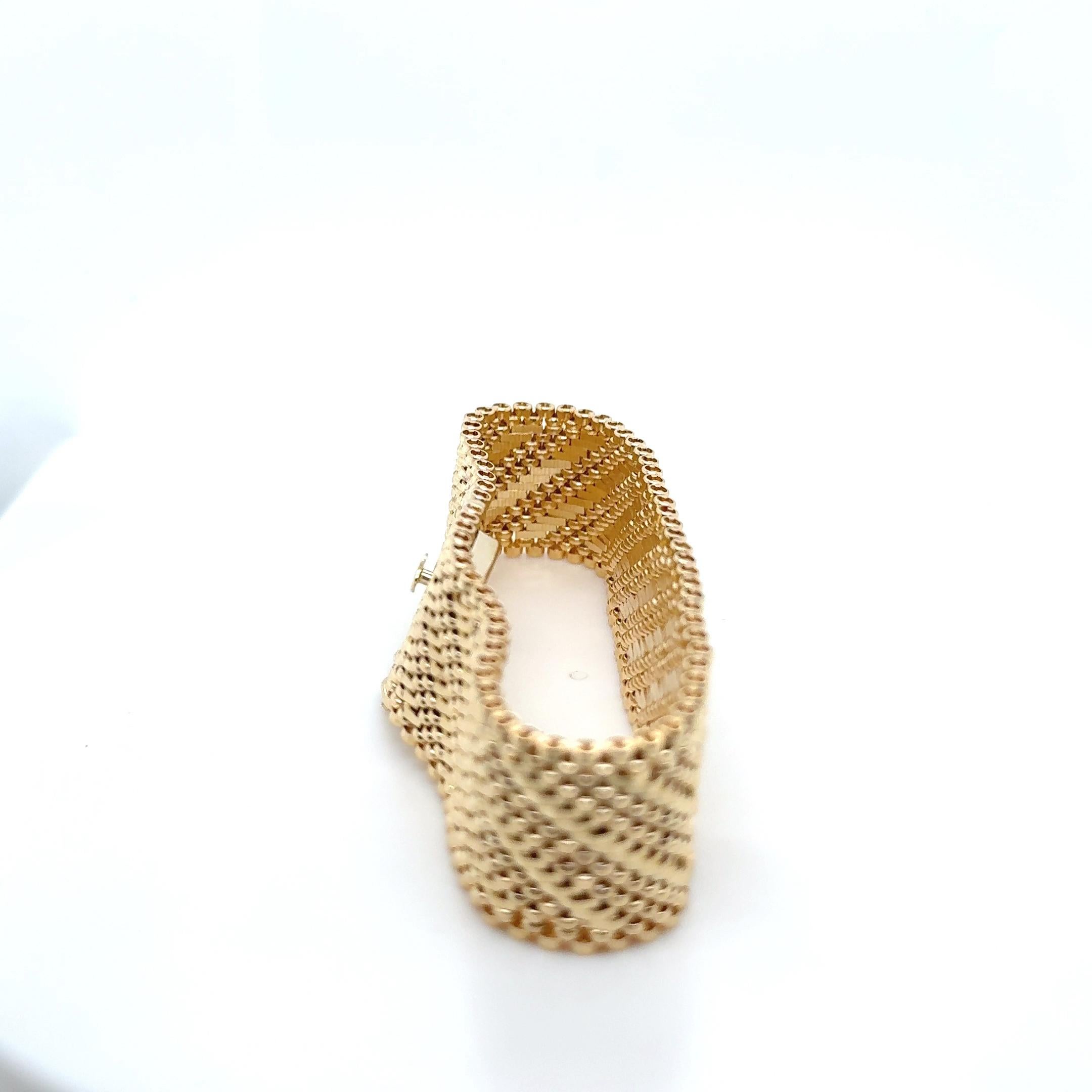 Questo elegante bracciale in oro giallo da 14 carati con finitura lucida e satinata misura 19 mm di larghezza e 7 pollici di lunghezza con chiusura a scatola e sicurezza a figura 8 per un peso totale di 42 grammi, presenta un'eccezionale struttura