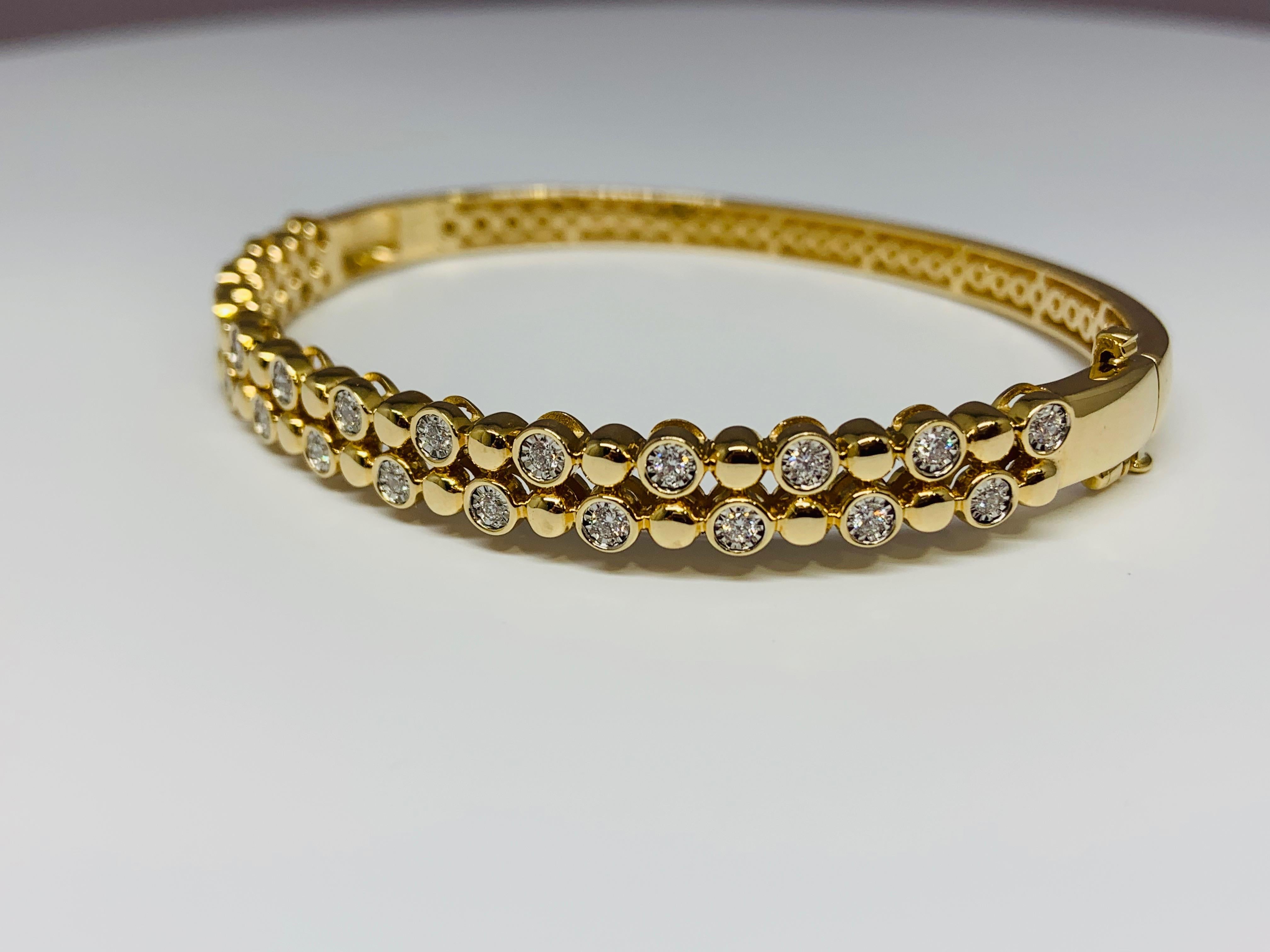 This gorgeous Allison-Kaufman Company 14K yellow gold bracelet features a 0.50 carat total weight of round white diamonds and bead detailing. This bracelet is hinged for easy opening and includes a box clasp and safety latch for ultimate security.  