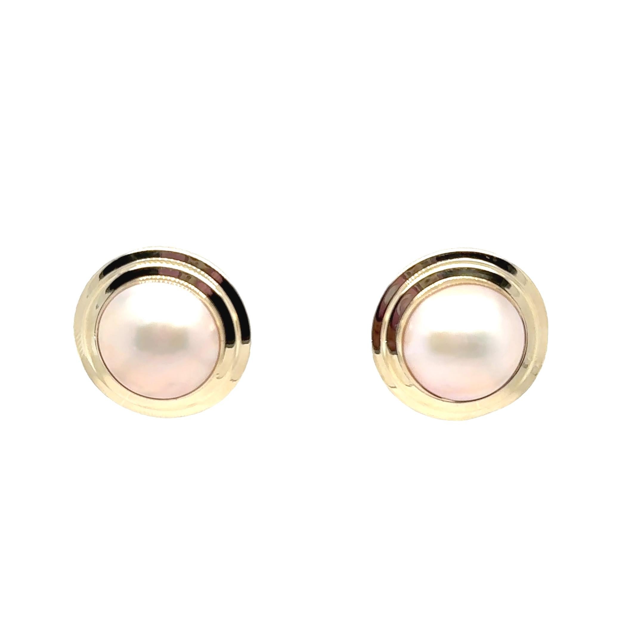 Questi eleganti orecchini a perno mettono in risalto la bellezza senza tempo delle perle Mabe, incastonate in un caldo oro giallo 14 carati. Ogni orecchino presenta una perla luminosa di circa 21,5 mm di diametro, famosa per il suo bagliore morbido