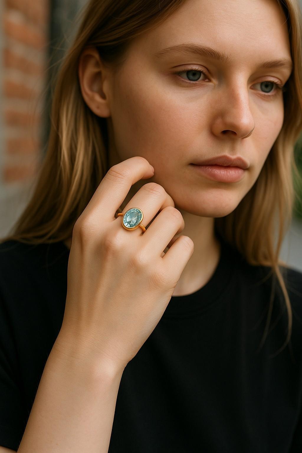 Faites une déclaration océanique avec cette bague solitaire en or jaune 14 carats sertie d'aigue-marine, qui présente une captivante aigue-marine ovale de 13 x 12 mm pesant un poids impressionnant de 6,85 carats. Sertie dans un riche chaton en or
