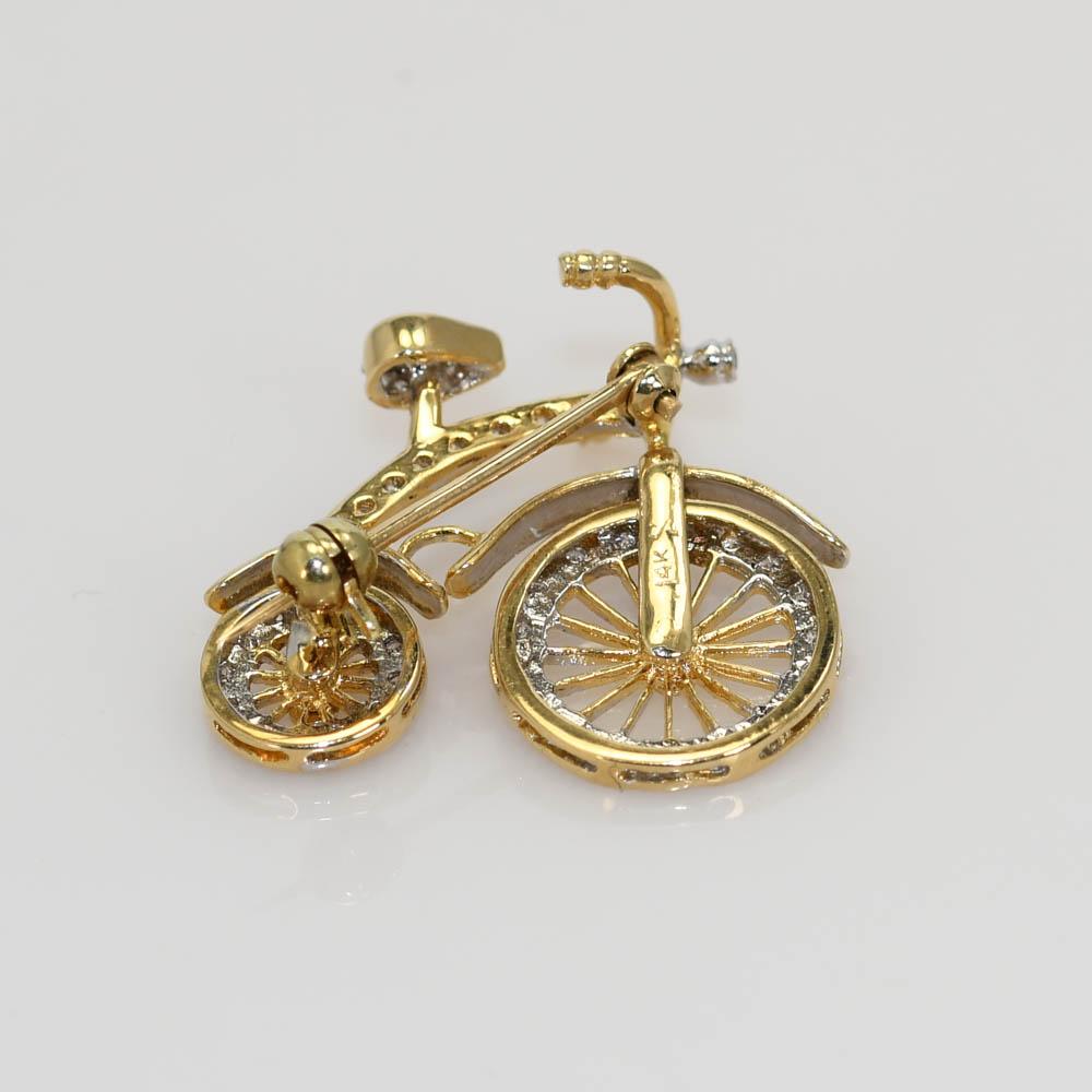 14k yellow gold and diamond Bicycle brooch.
Stamped 14k and weighs 3.2 grams.
The diamonds are round brilliant cuts, .20 total carats.
G,H,I color range, Si clarity.
Both wheels on the bicycle turn.
The brooch measures 7/8 x 3/4 inches.
Excellent