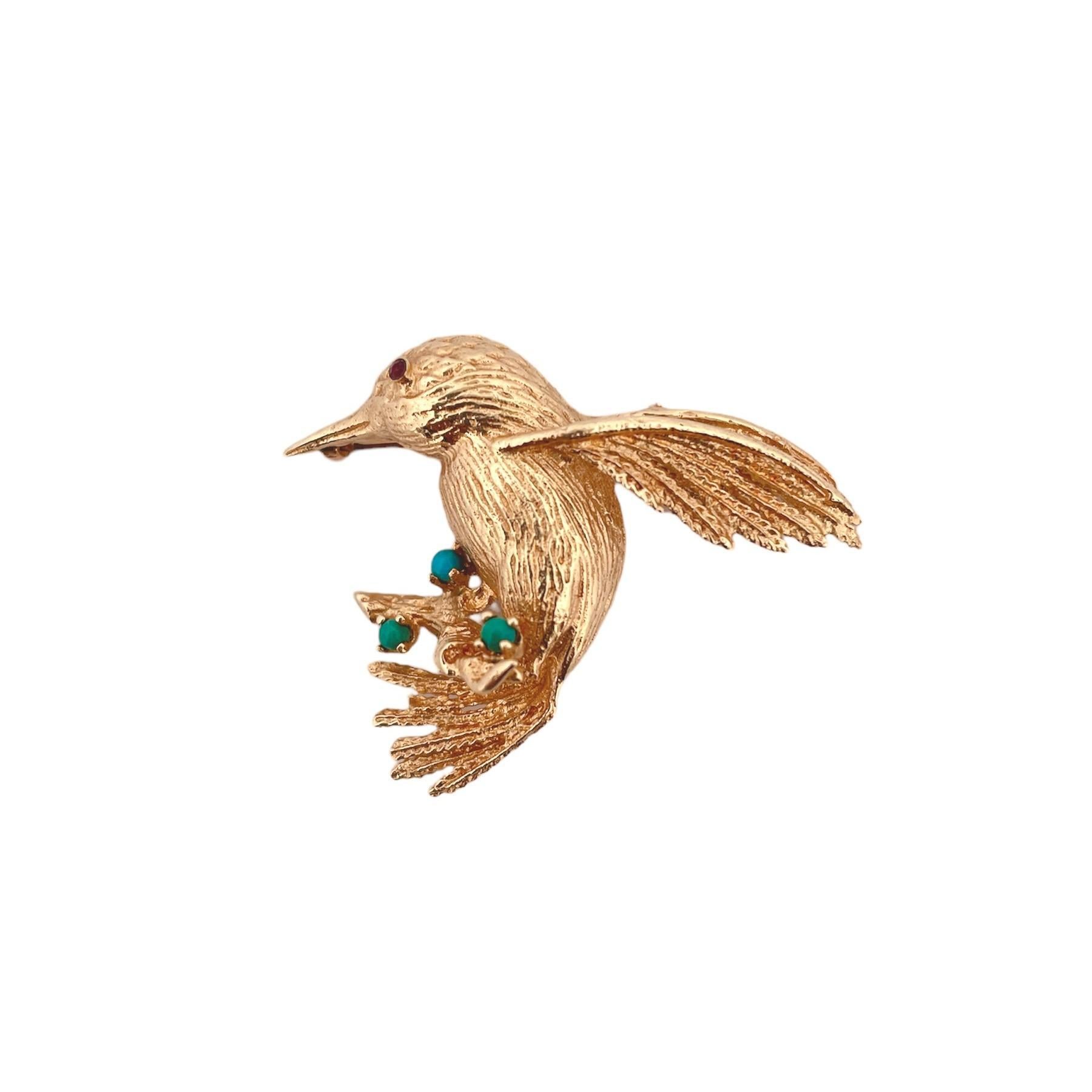 Broche en forme d'oiseau, un superbe hommage à la grâce de la beauté aviaire et à l'attrait des pierres précieuses naturelles. 
Cette broche enchanteresse, d'un poids substantiel de 7,4 grammes, est méticuleusement réalisée en or jaune 14 carats et