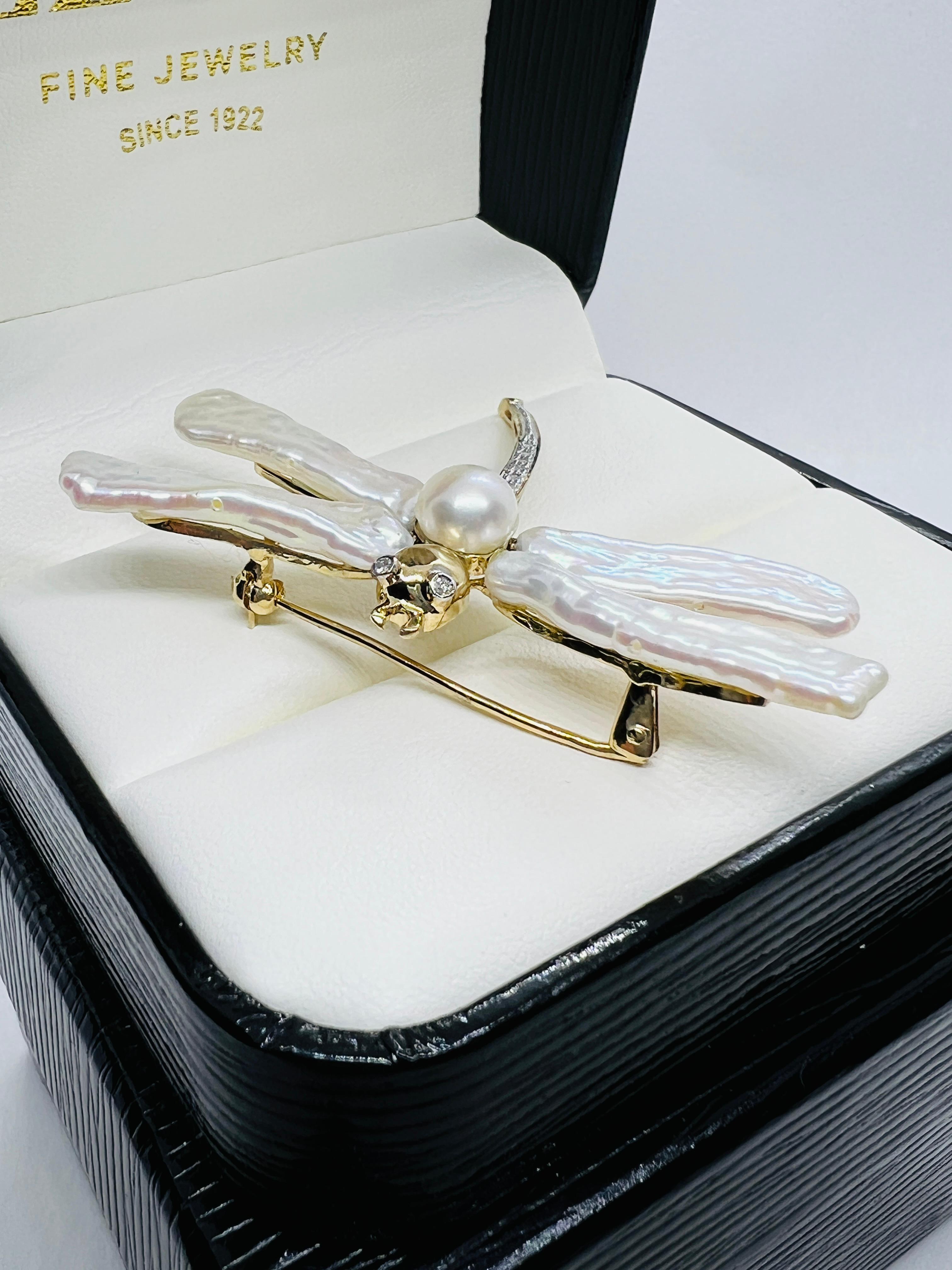 This is such a gorgeous Dragonfly Brooch! Made in 14 K Yellow Gold. The body consists of 8 round diamonds. The eyes are 2 bezel set round diamonds. The wings are Biwa pearls and there is a single 7mm pearl at the center of the wings. It measures