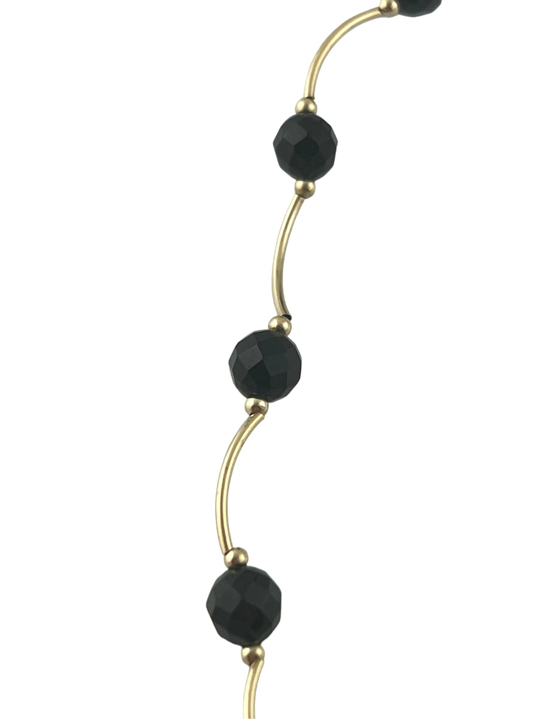 Beautiful 14k yellow gold black onyx bead necklace features 18 onyx beads separated by half an inch of curved 14k yellow gold bars.

Length: 15.5
