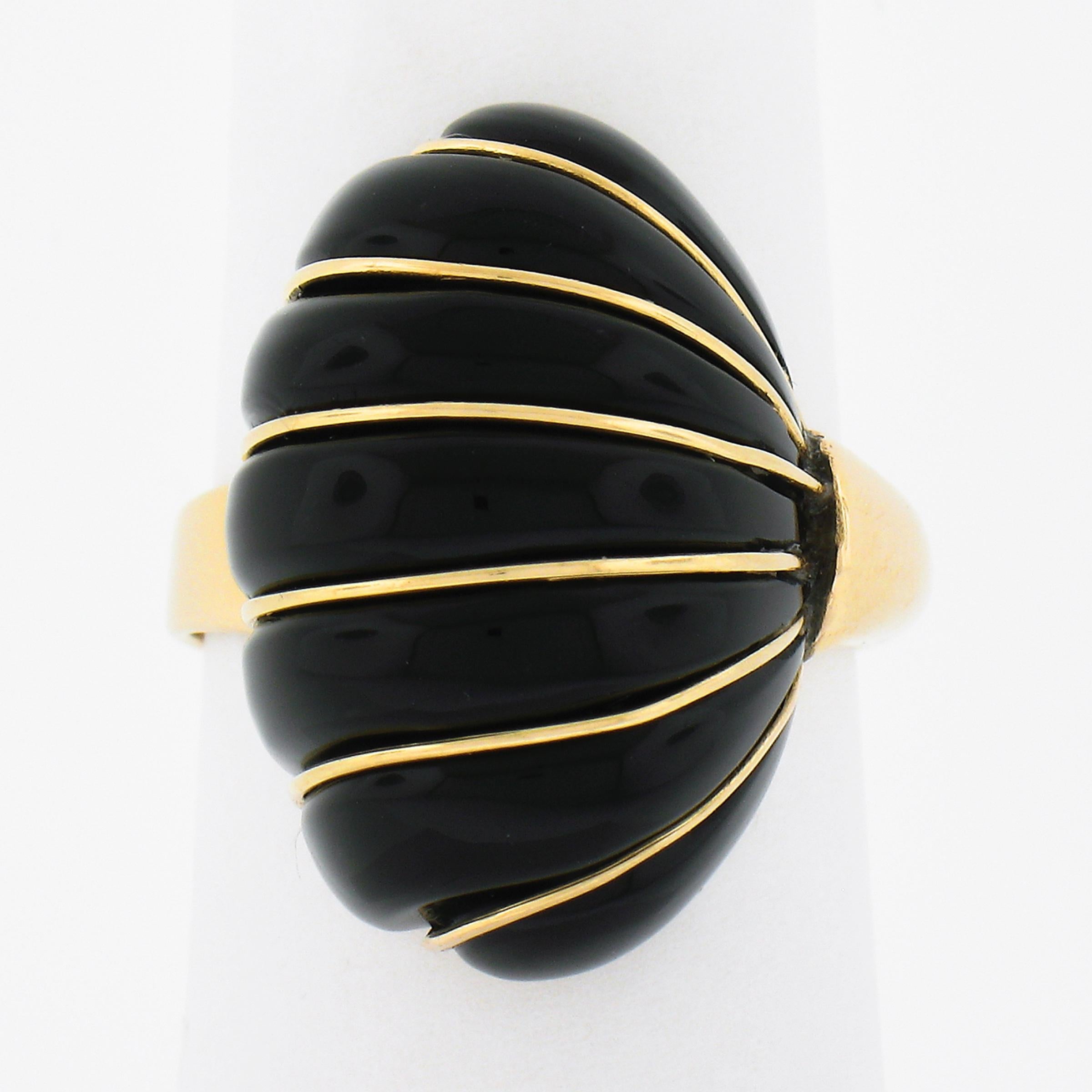 Cette magnifique bague de cocktail en or jaune massif 14 carats présente un ravissant et unique motif en forme de coquillage festonné, composé d'une véritable pierre d'onyx noir. Sa grande taille et sa couleur noire pure confèrent à cette bague une