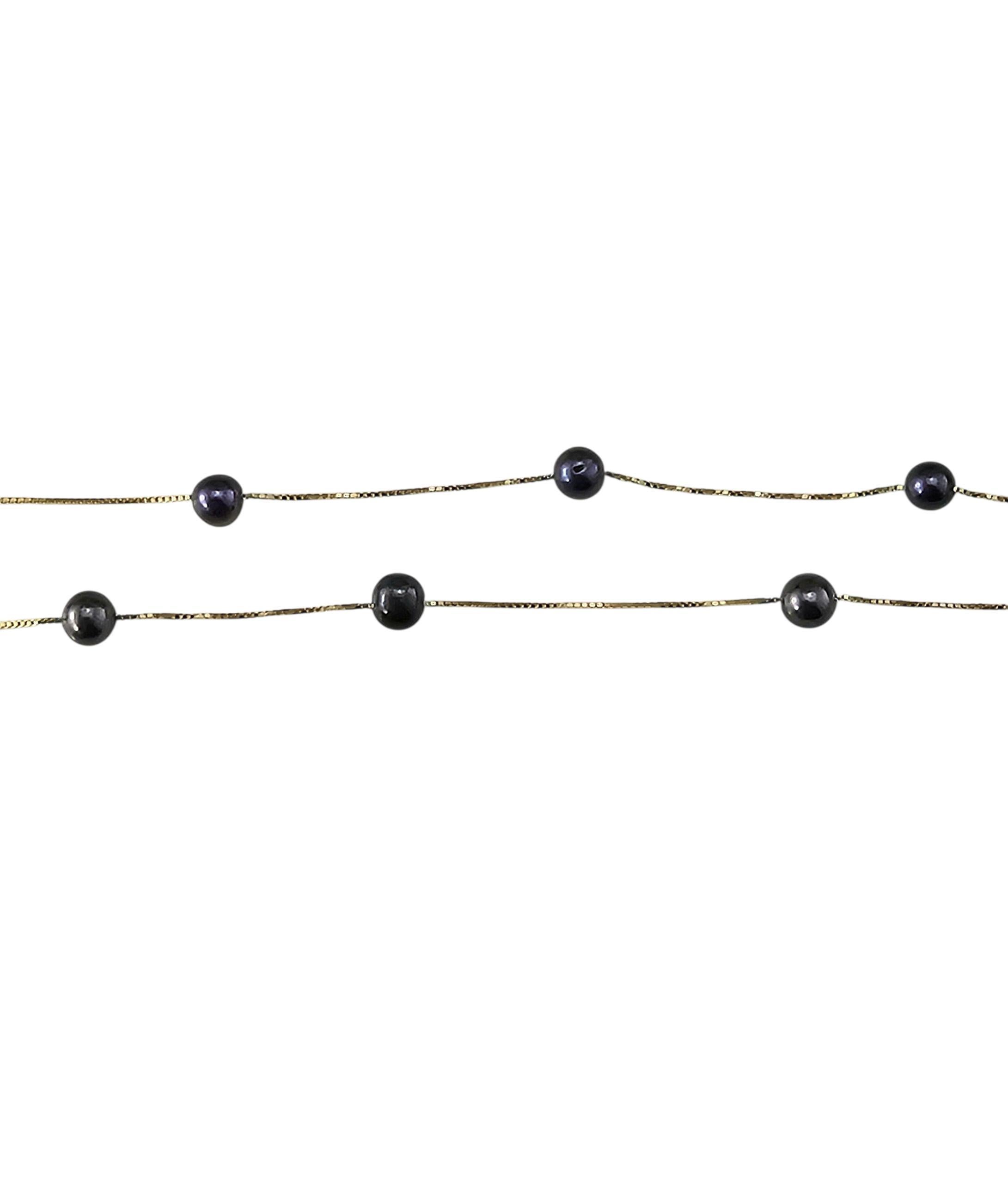 Collier de perles noires en or jaune 14K...

Cet élégant collier est parsemé de 11 perles noires rondes (5 mm chacune), chacune présentant de doux reflets de paon. Les perles sont disposées uniformément le long de la chaîne, ce qui leur confère un