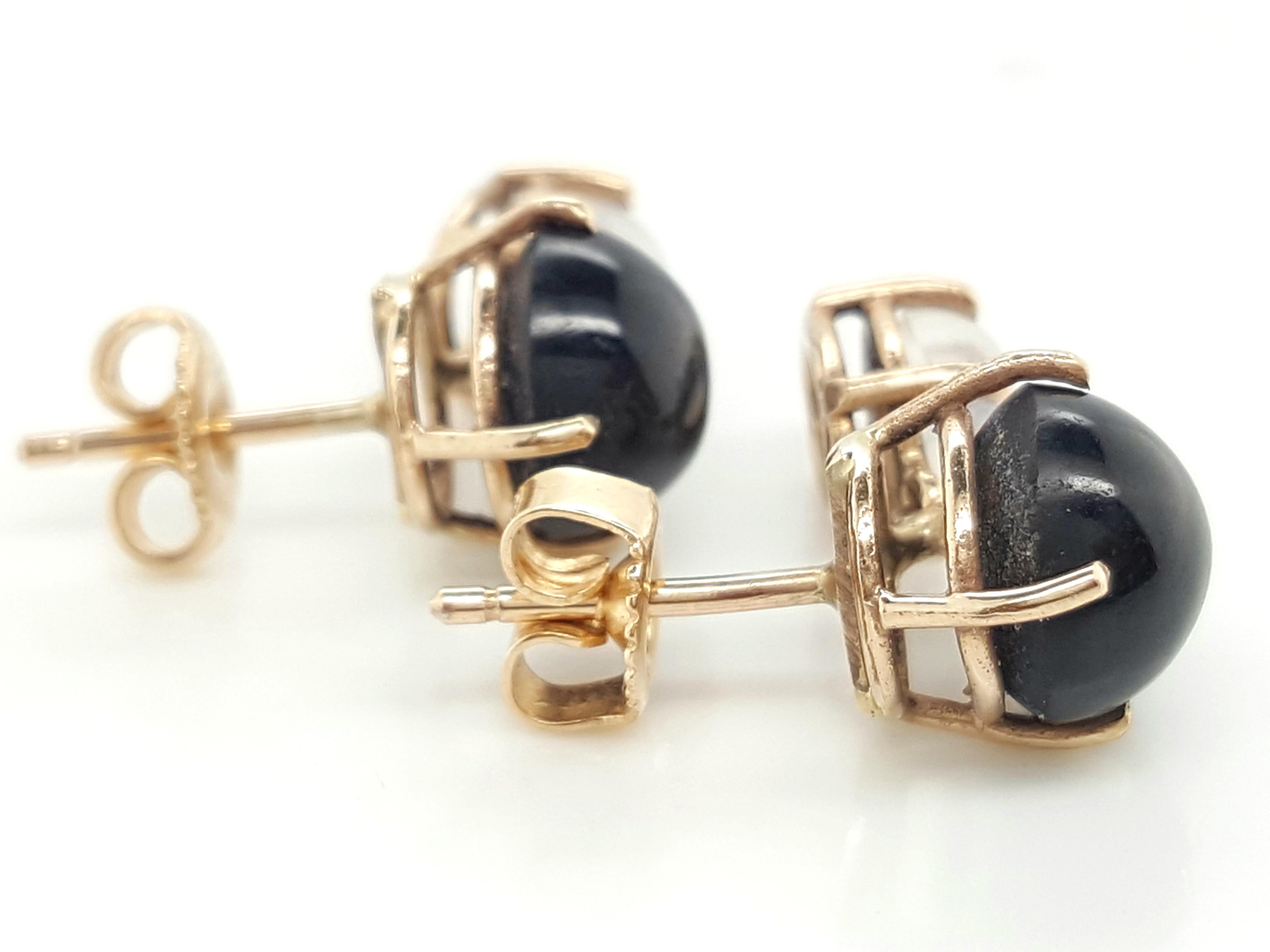 14 Karat Yellow Gold Black Star Diopside and Moonstone Earrings  The earrings feature a pair of black star diopside each set into a 14 karat yellow gold four prong basket setting.   Suspended from the star diopside are.a pair of oval cabochon