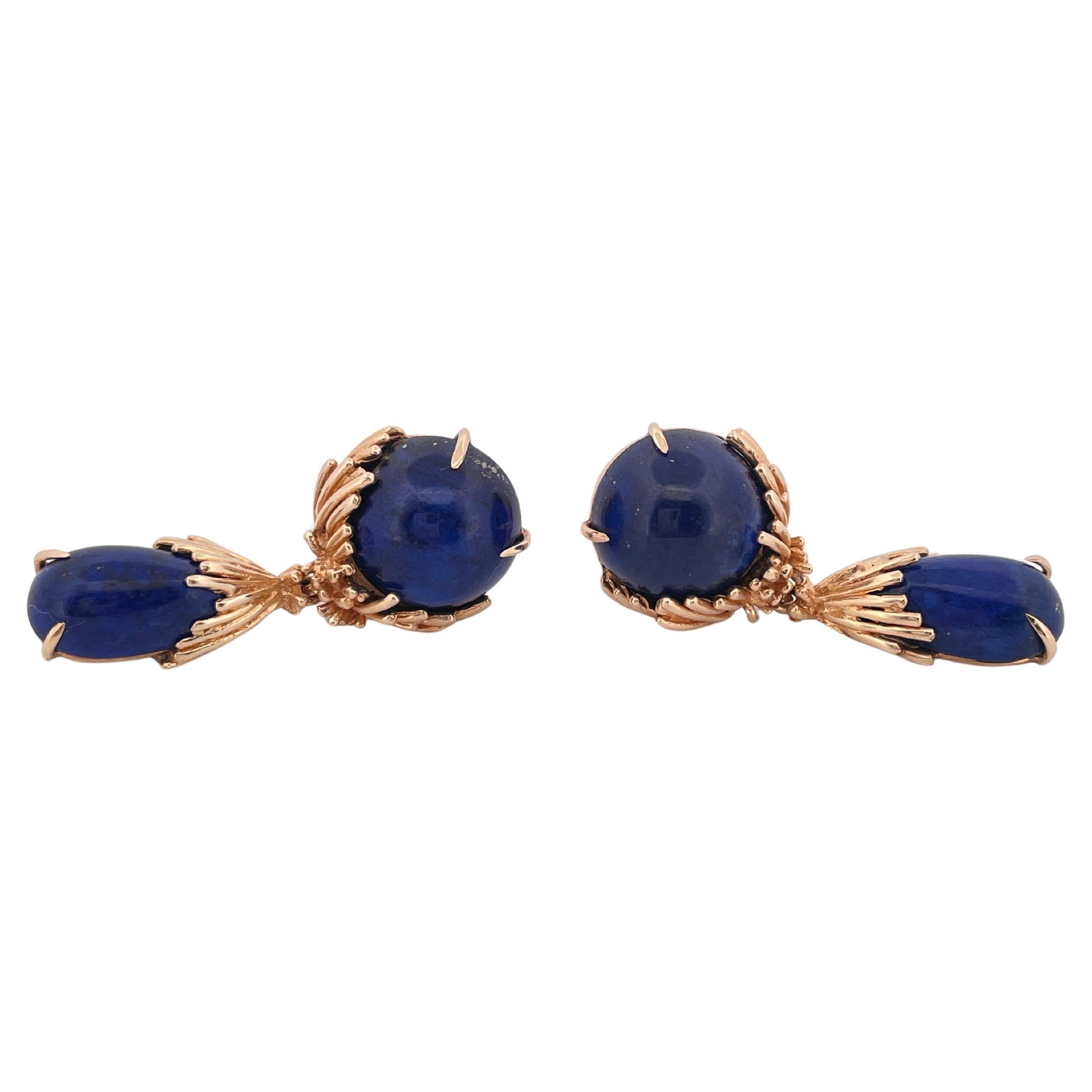 These elegant vintage earrings are crafted in rich 14k yellow gold and set with striking deep-blue lapis lazuli cabochons. Each earring features a round lapis stone surmounted by a gracefully elongated teardrop, both securely held in finely detailed