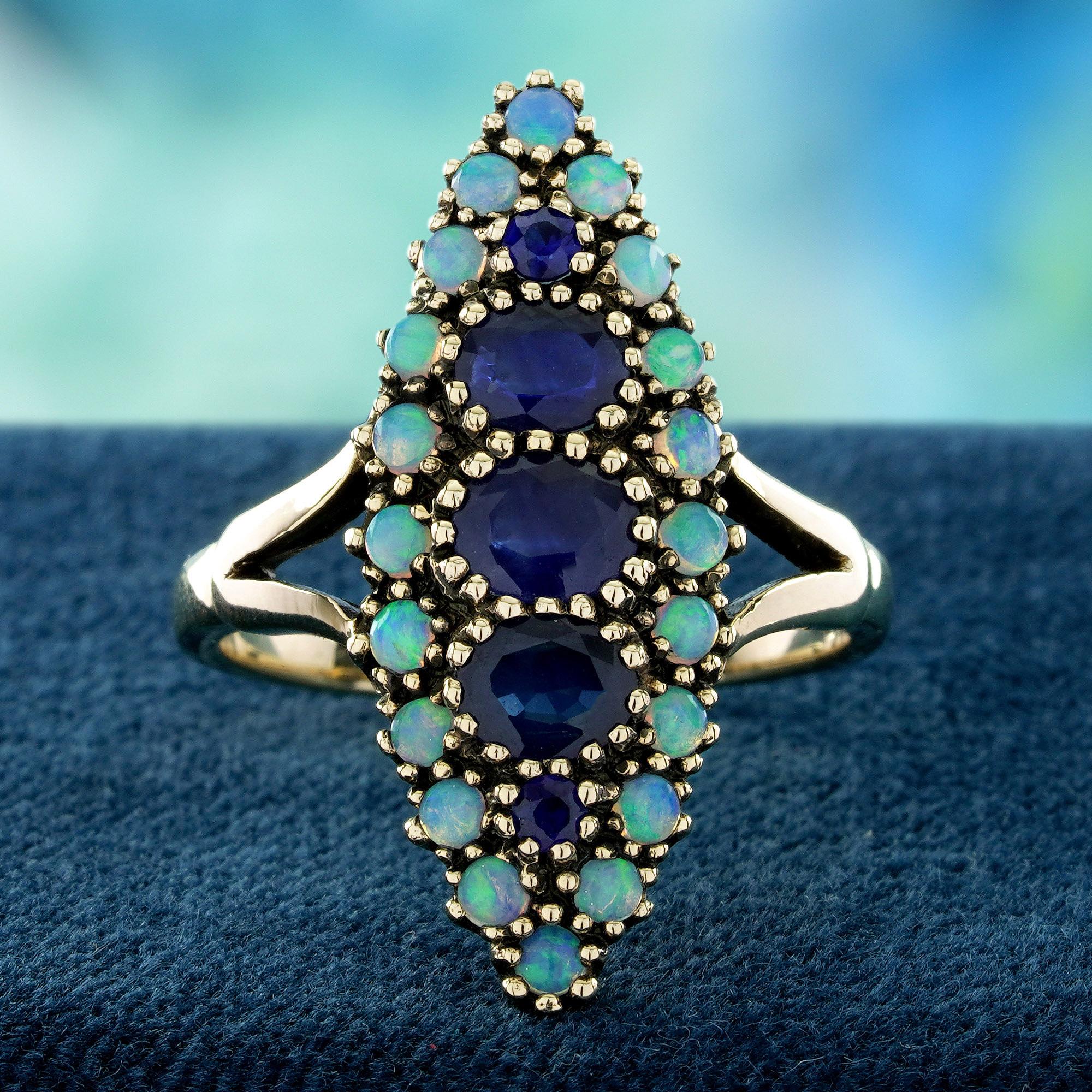 Sein Herzstück, ein tiefblauer Saphir mit samtigem, seidigem Glanz, ist vertikal gefasst und bildet einen eleganten Blickpunkt. Dieser bezaubernde Edelstein wird von einem Heiligenschein aus ätherischen Opalen umrahmt, deren schillernde Farbspiele