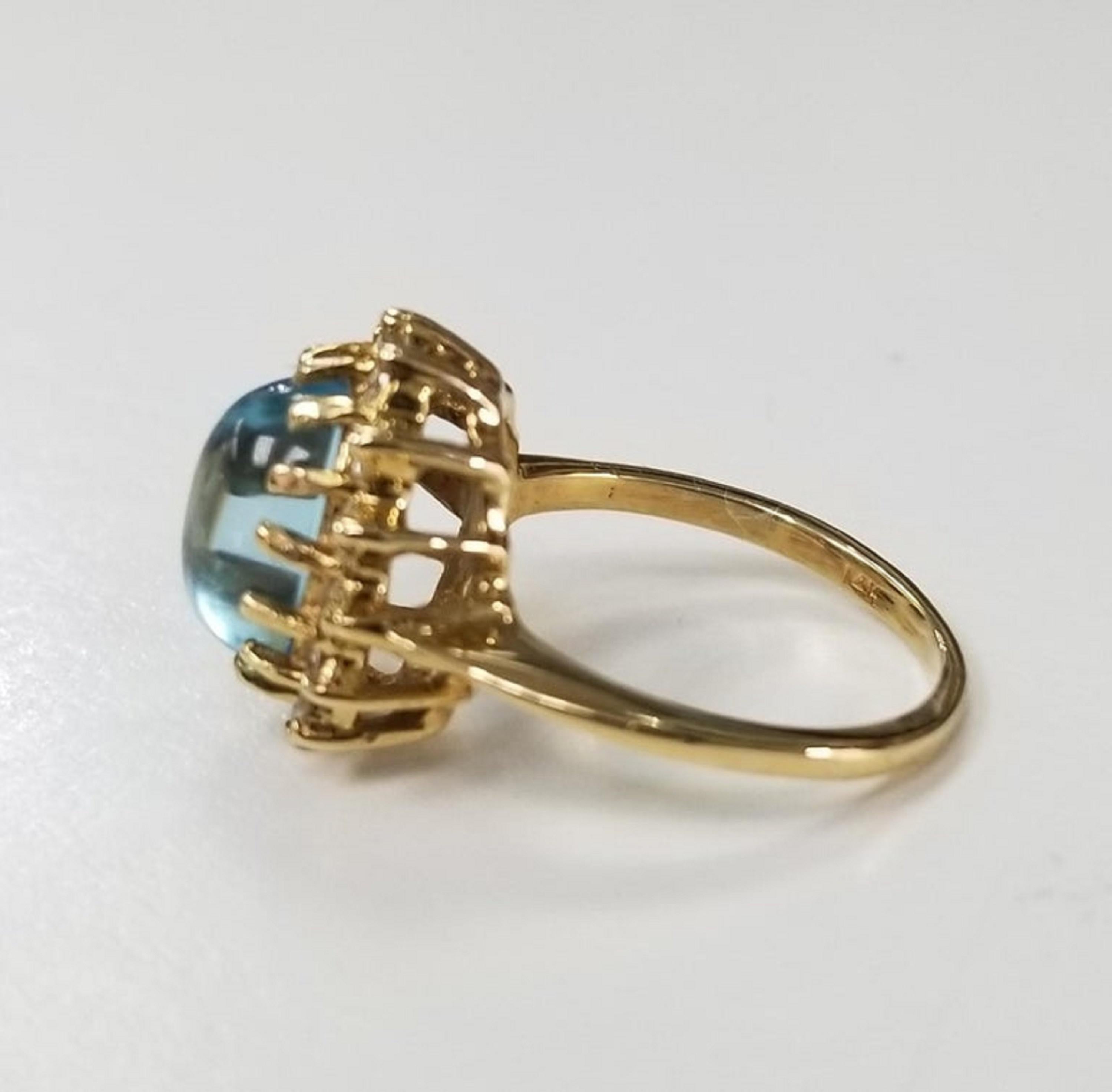 14k yellow gold Blue Topaz Cabochon and Diamond ring, containing 1 oval cabochon cut blue topaz weighing 3.75cts. and 14 round full cut diamonds weighing .40pts.  This ring is a size 5 but we will size to fit for free.