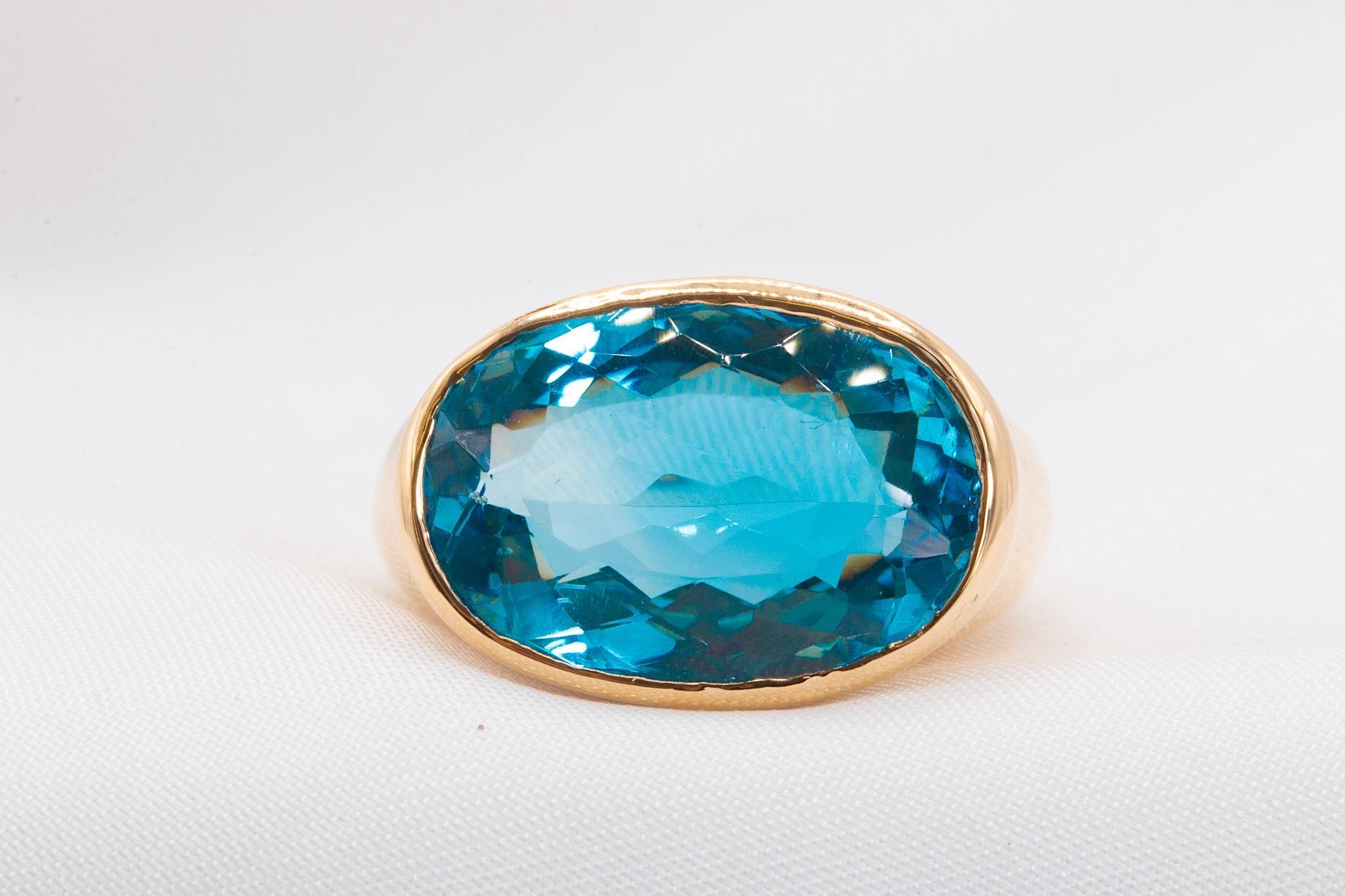 Cette bague exceptionnelle est fabriquée avec expertise en or jaune 14 carats et met en valeur une topaze bleue ovale mesurant environ 17,7 x 12,5 mm. Pesant 15 grammes, cette pièce exceptionnelle est actuellement une taille 5,75, avec des options