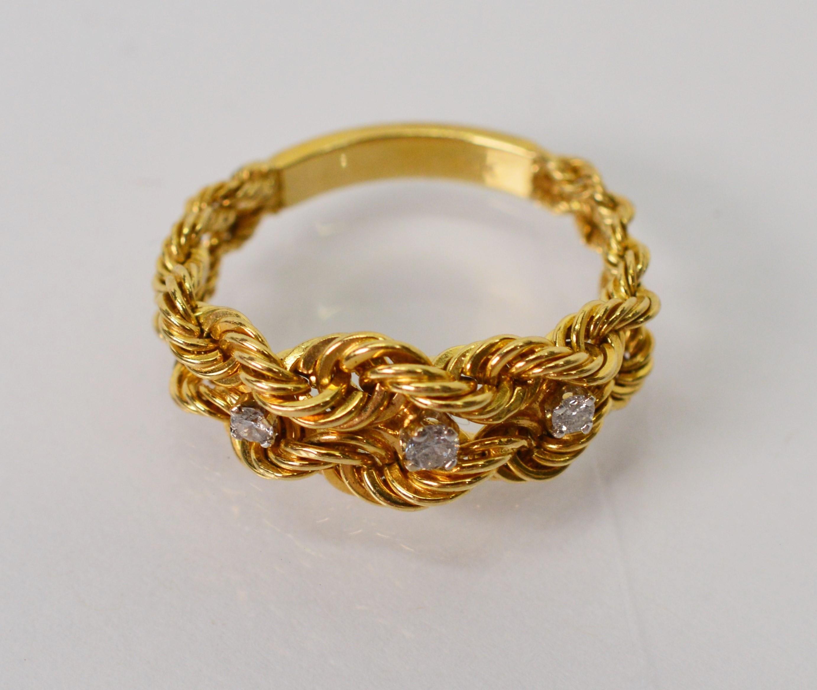 Enjoy the creativity of this unusual fourteen karat 14k yellow gold braided rope chain ring appointed with three diamonds accents. The band has a solid back and transitions to a braided and graduated rope chain face with three .02 carat diamonds