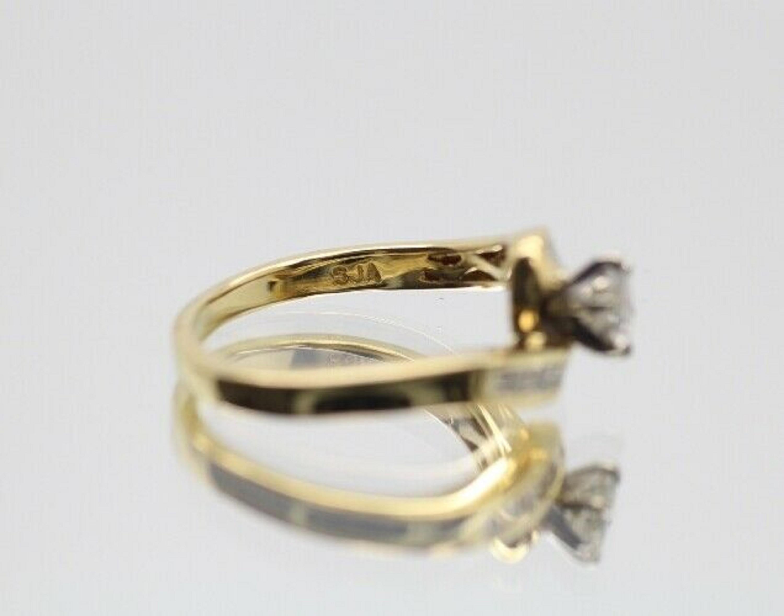 A unique ring with a band that overlaps to showcase the beautiful round center stone in 0.50 carat weight G color and SI2 stone clarity.The overlap twist ring has a 16 pieces of straight baguette cut diamonds in approximately 0.50 carat total