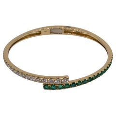 14 Karat Gelbgold Bypass-Armreif mit abgestuften Smaragden und Diamanten im Rundschliff