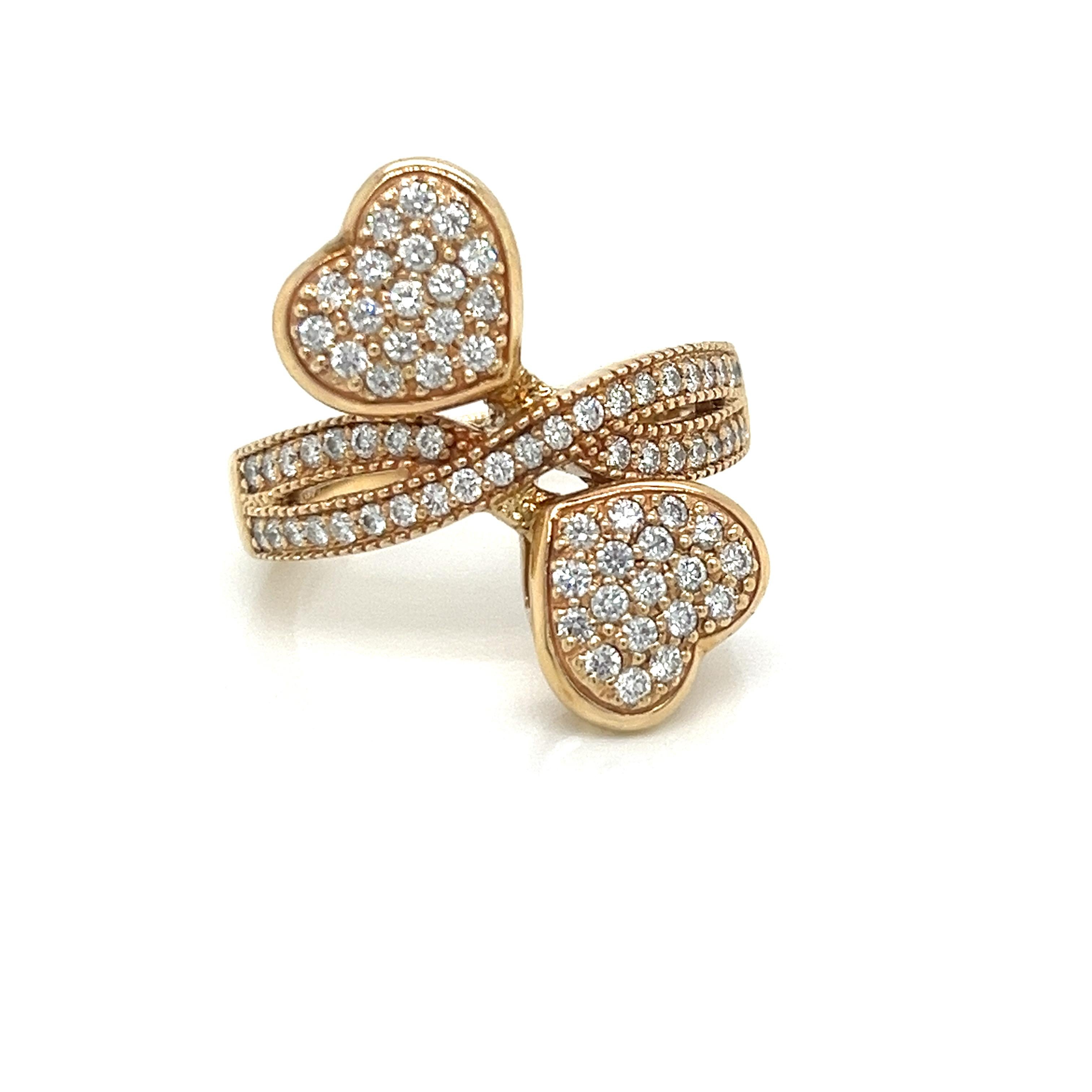 This stunning 14k yellow gold ring features a beautiful bypass design with two pave-set diamond hearts. Each heart measures 11mm wide and 10mm tall, exquisitely adorned with 18 brilliant-cut pave diamonds for a total of 36 dazzling diamonds weighing