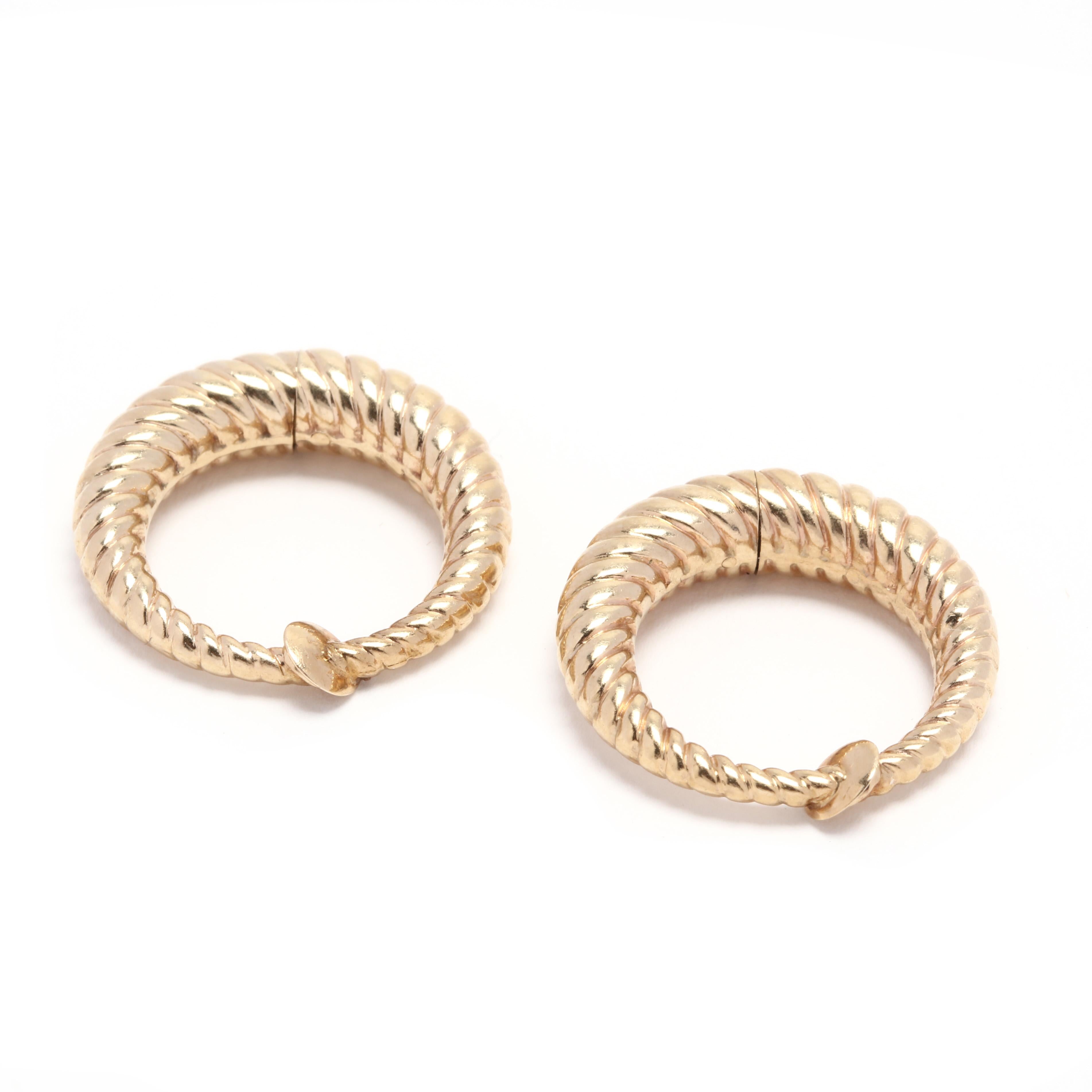 A pair of 14 karat yellow gold cable clip on hoop earrings. These earrings feature a tapered cable hoop design with a hinge at the bottom so that the top may clip on to the ear lobe.

Length: 7/8 in.

4.45 dwts.

* Please note that this is a vintage