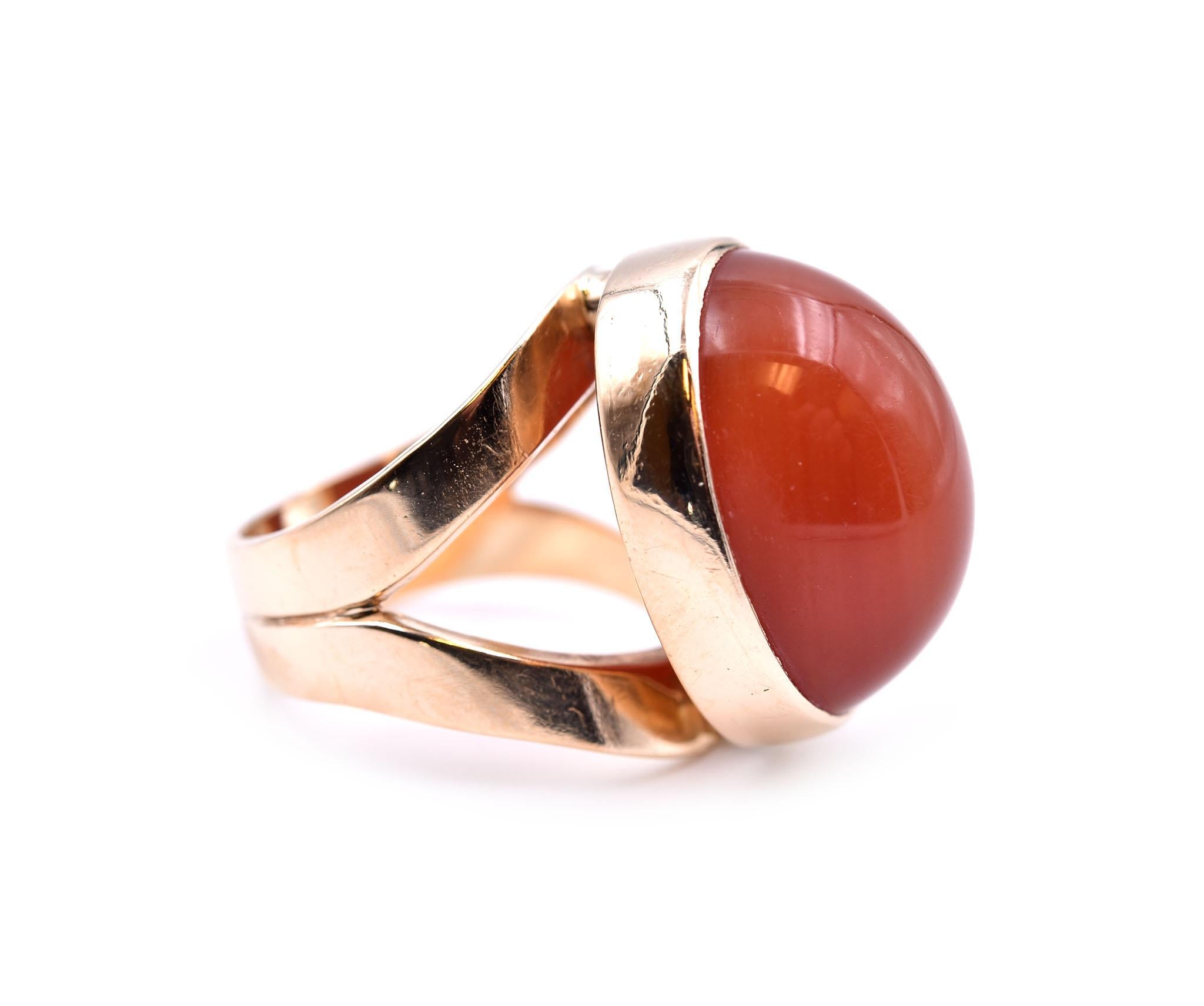 Designer: custom design
Material: 14k yellow gold
Gemstone: cabochon cut carnelian
Dimensions: ring top measures 21.35mm by 16.30mm
Ring size: 6.5 (please allow two additional shipping days for sizing requests) 
Weight: 12.79 grams 