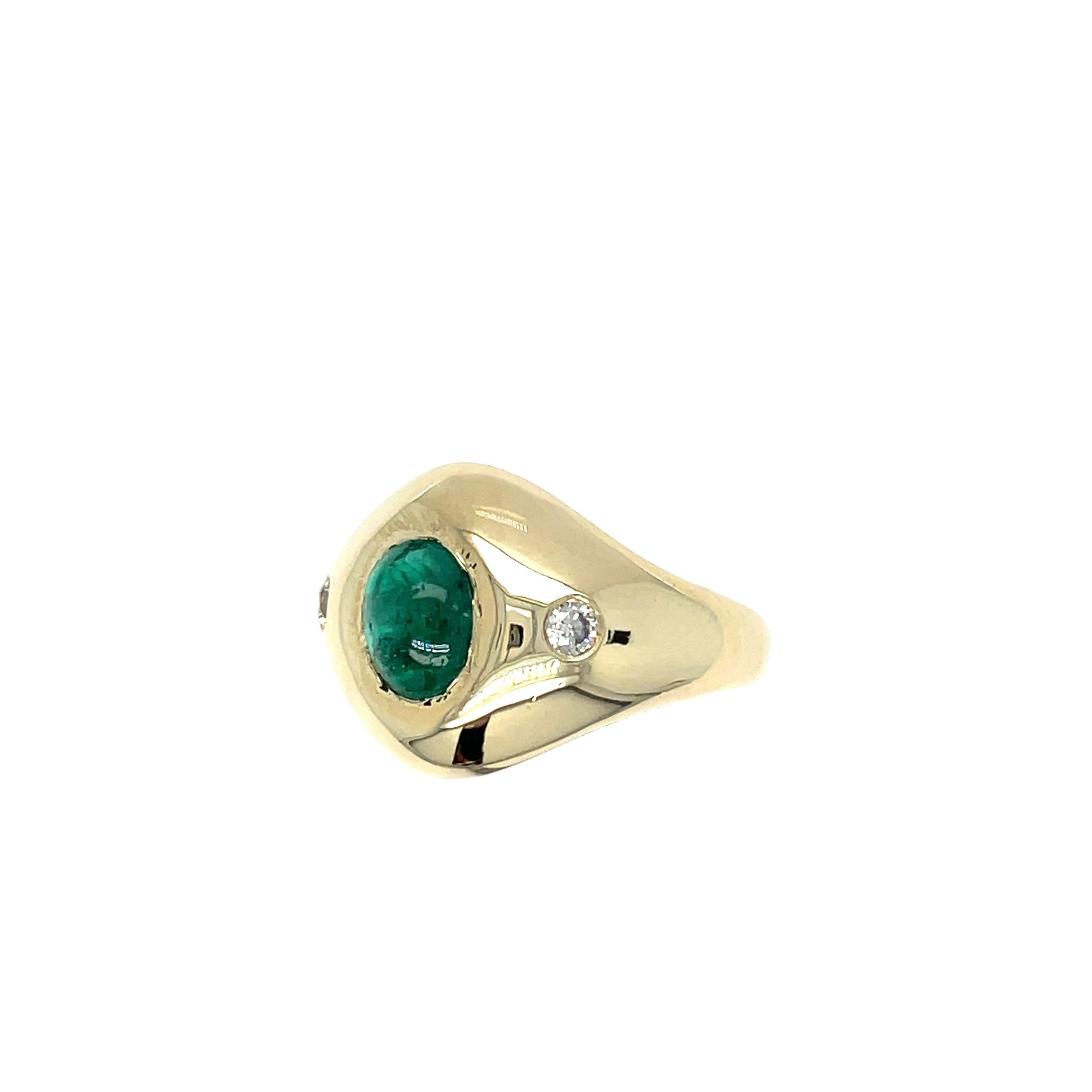 The ring is made of 14k gold and features a classic 3-stone style. The center stone is a large oval cabochon emerald with a high dome, which makes it stand out on the hand. The emerald is 1.52 carats and exhibits a deep green color with very good