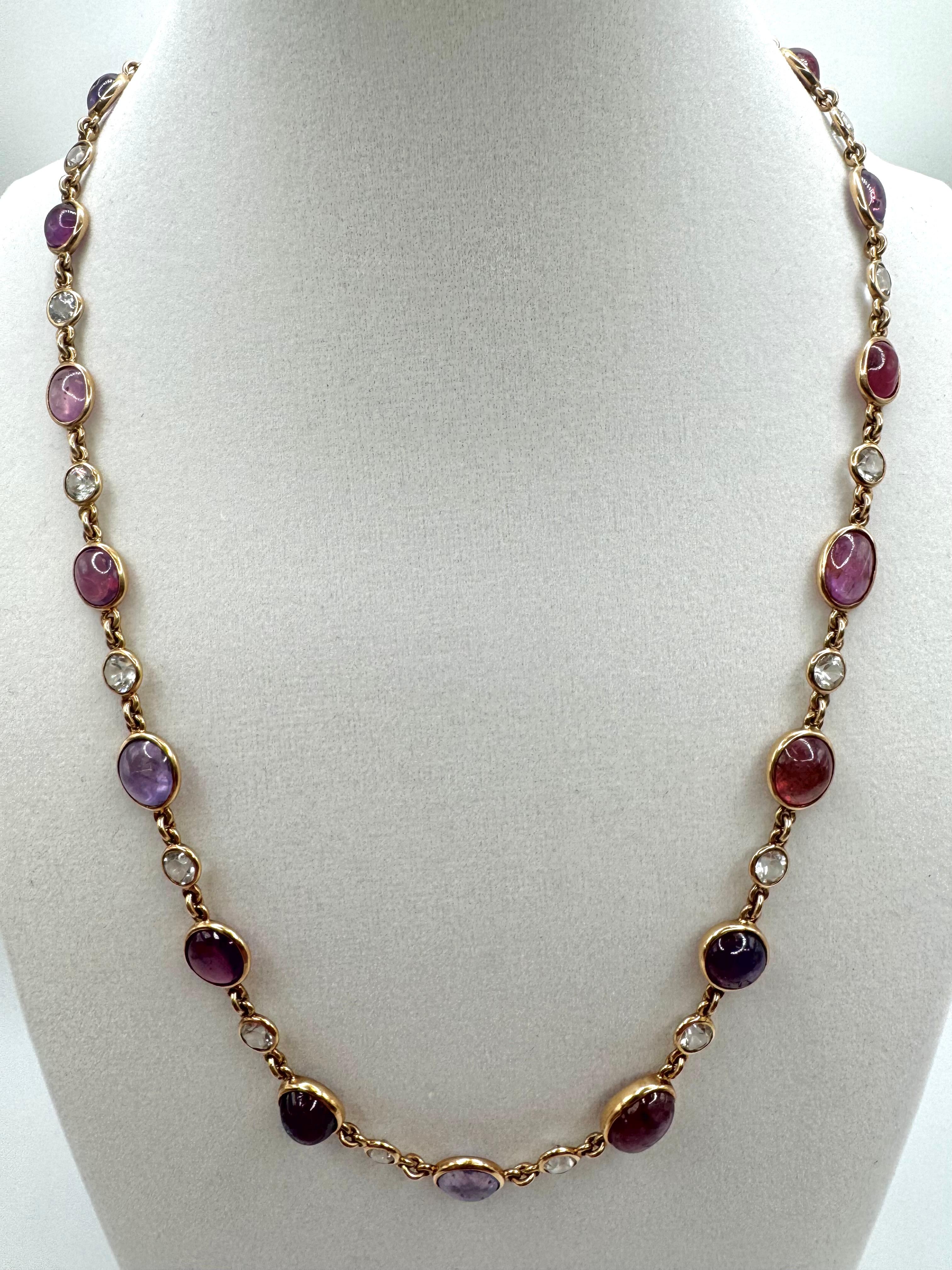 This striking 14K yellow gold necklace from the 1970s–1980s showcases a colorful array of approximately 35 carats of natural cabochon sapphires in vibrant shades of lavender, plum, and raspberry, elegantly alternated with shimmering colorless