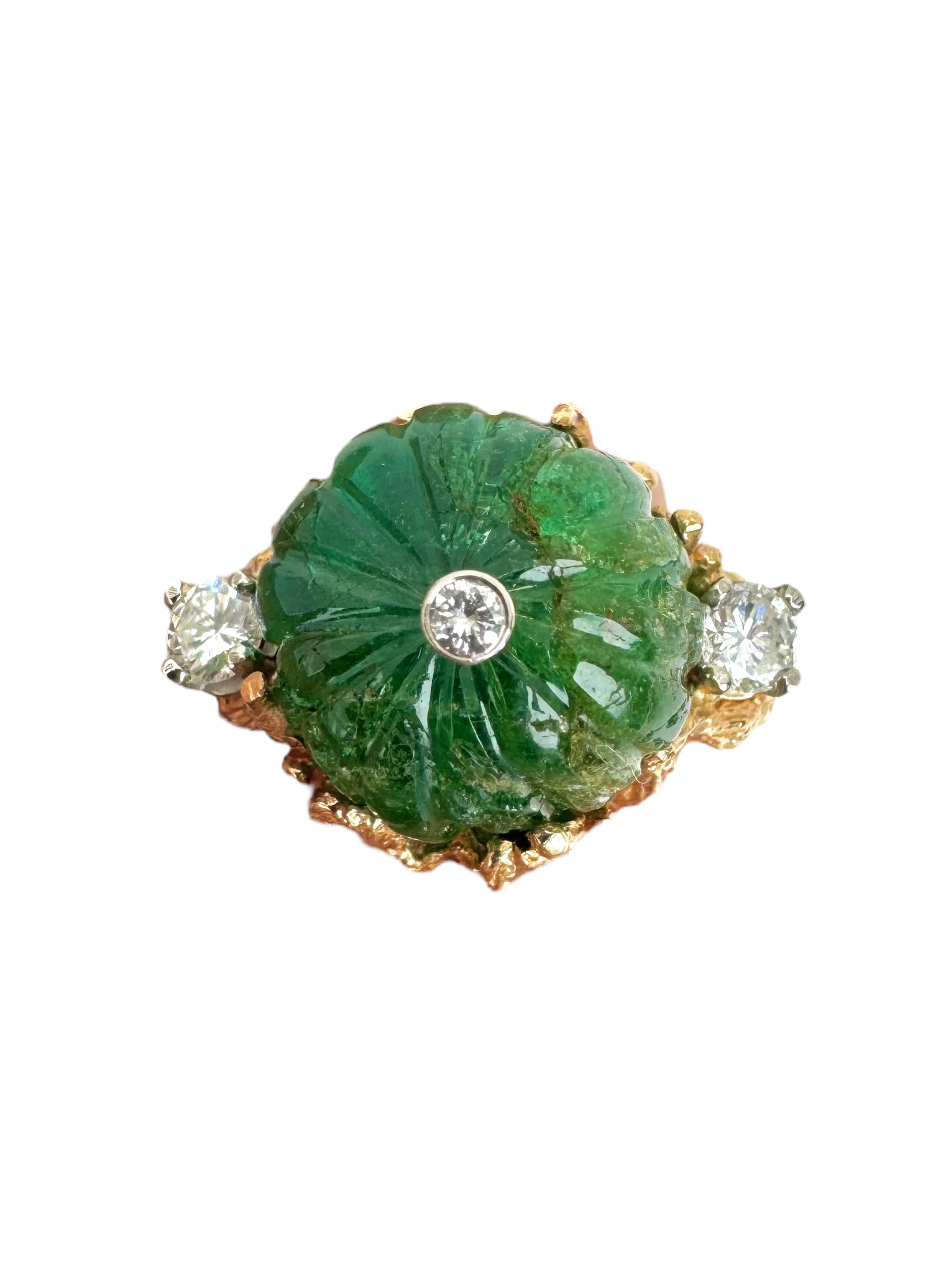 Cette bague du milieu du siècle présente une émeraude florale magistralement sculptée pesant environ 16,29 carats, sertie dans une monture en or jaune 14 carats richement texturée. La pièce centrale d'un vert éclatant est rehaussée de trois diamants