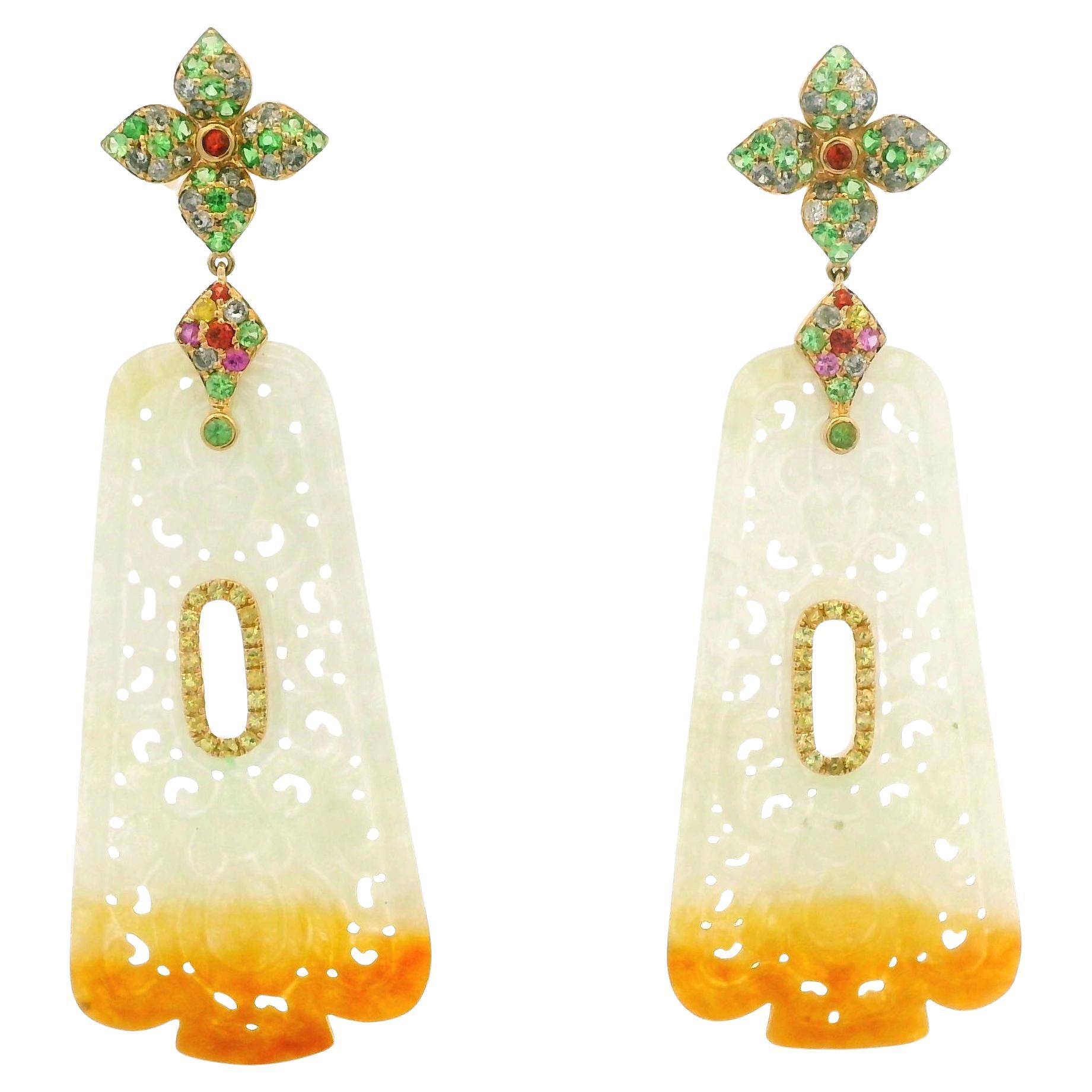 These statement earrings blend traditional craftsmanship with vibrant gemstones to create a truly unique piece. Crafted in 14 karat yellow gold, the design centers on two large carved jade drops totaling 25.54 carats, with a gentle gradation from