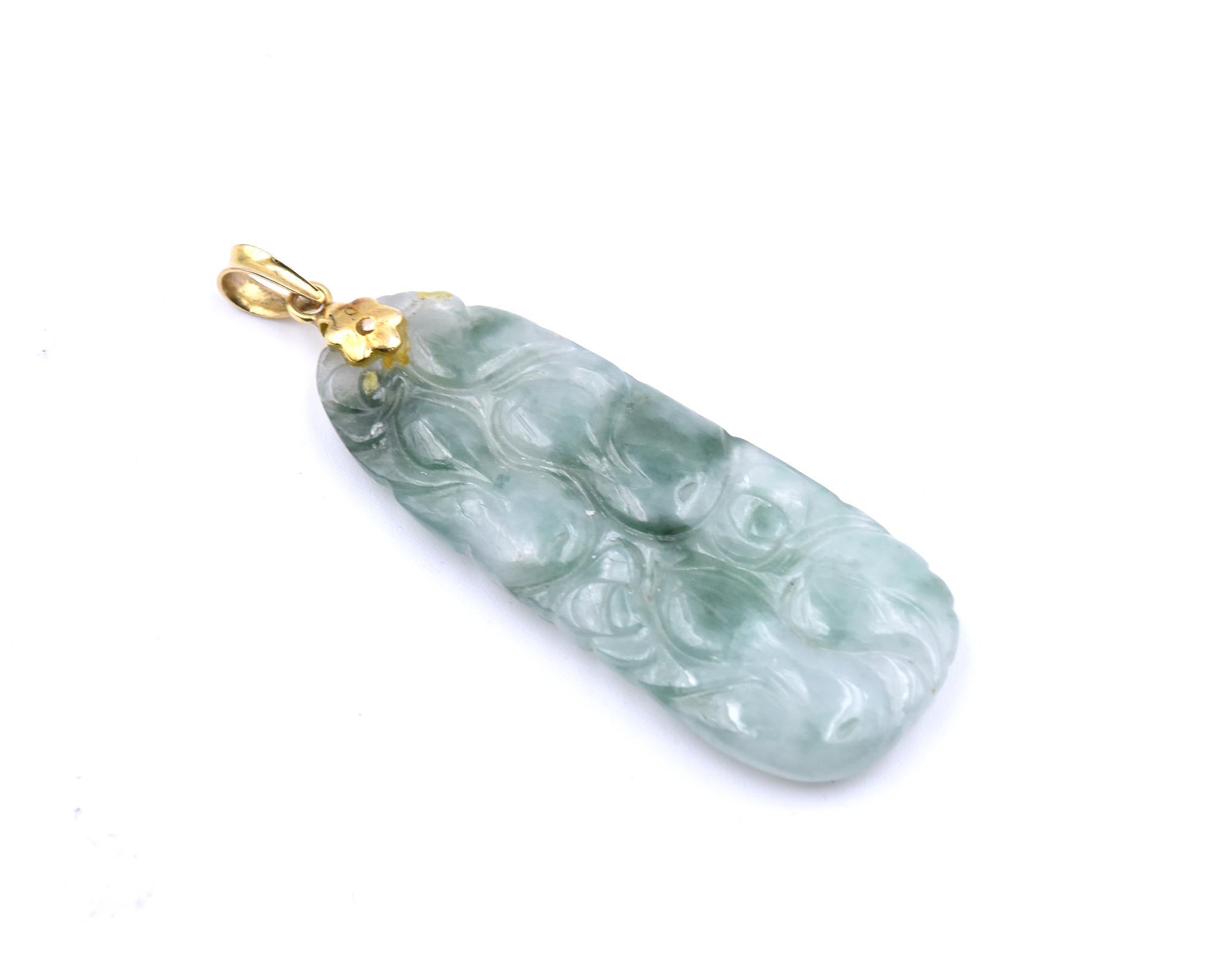 Designer: custom design
Material: 14k yellow gold 
Gemstones: jade
Dimensions: pendant measures 2 ¼-inch long with vail and it is 18.87mm wide
Weight: 8.61 grams
