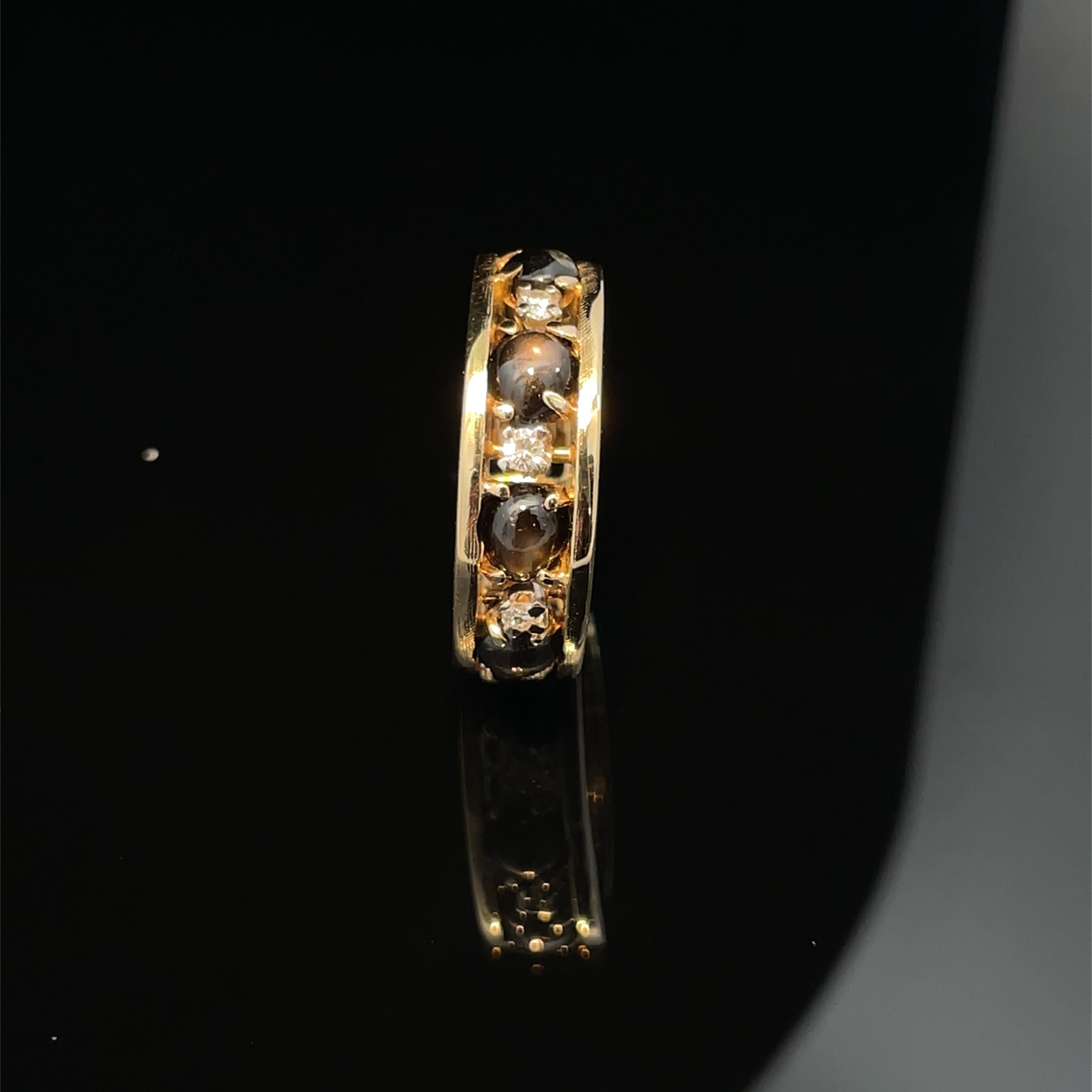 Prova il fascino dell'anello a fascia con occhio di gatto e diamante in oro giallo 14k, un capolavoro di eleganza moderna. Questo squisito pezzo mette in mostra le affascinanti pietre Cat's Eye, la cui misteriosa lucentezza è splendidamente