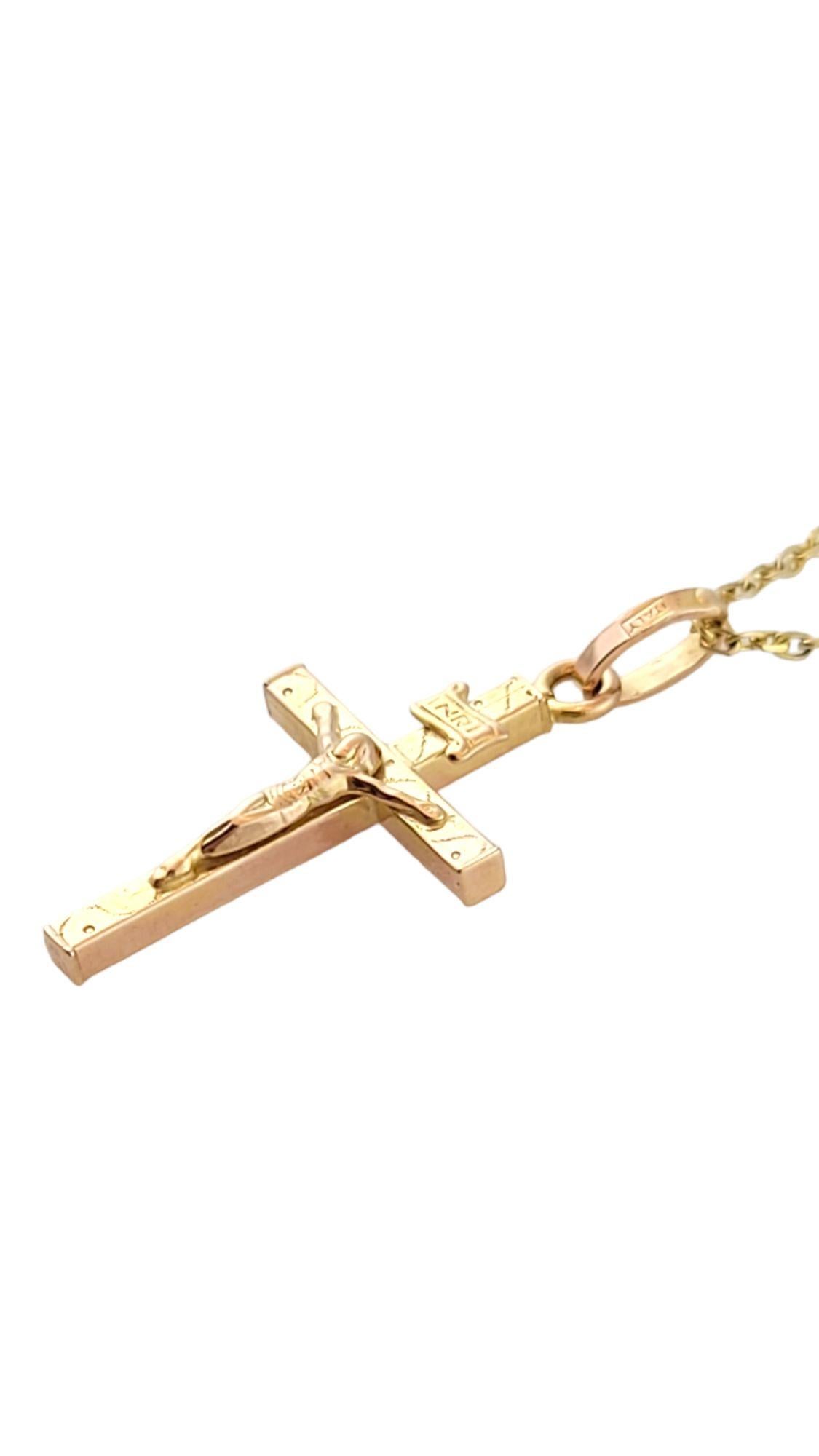 This pendant features a crucifix with 