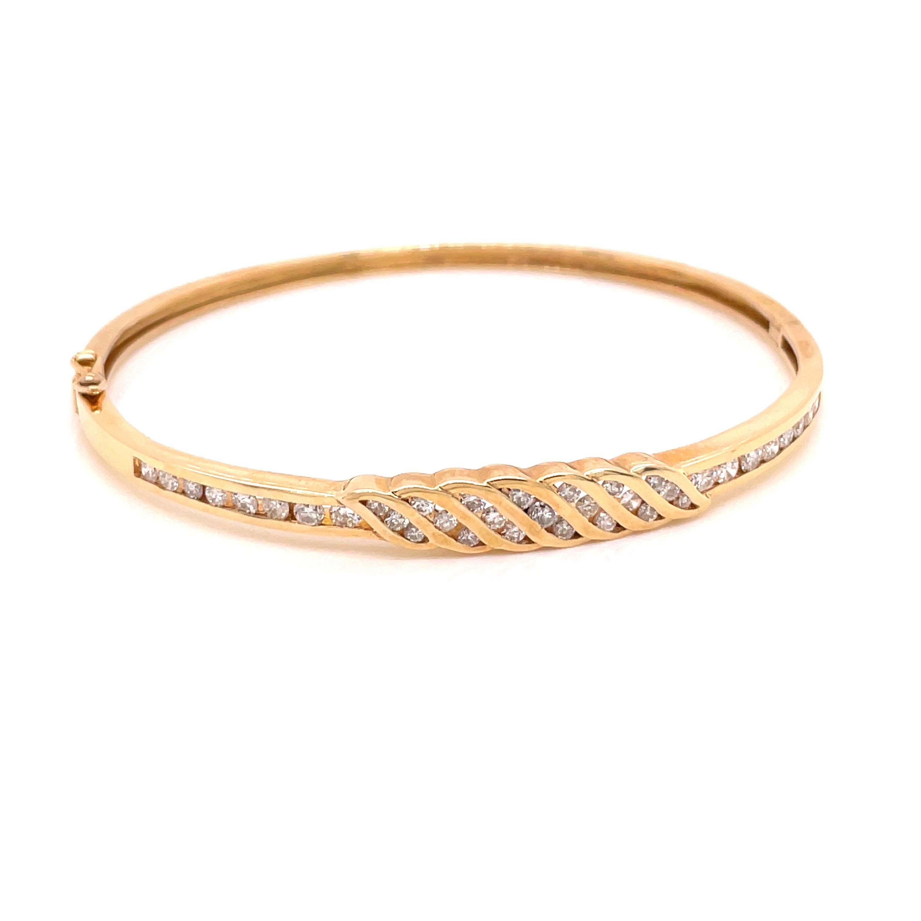14K Yellow Gold Channel Design Diamond Bangle Bracelet 1.04ct - The bangle is set with 37 round brilliant diamonds weighing 1.04ct with H - I color and SI clarity. The width of the bangle on top is 5.5mm and tapers to 2.5mm on the bottom. The inside