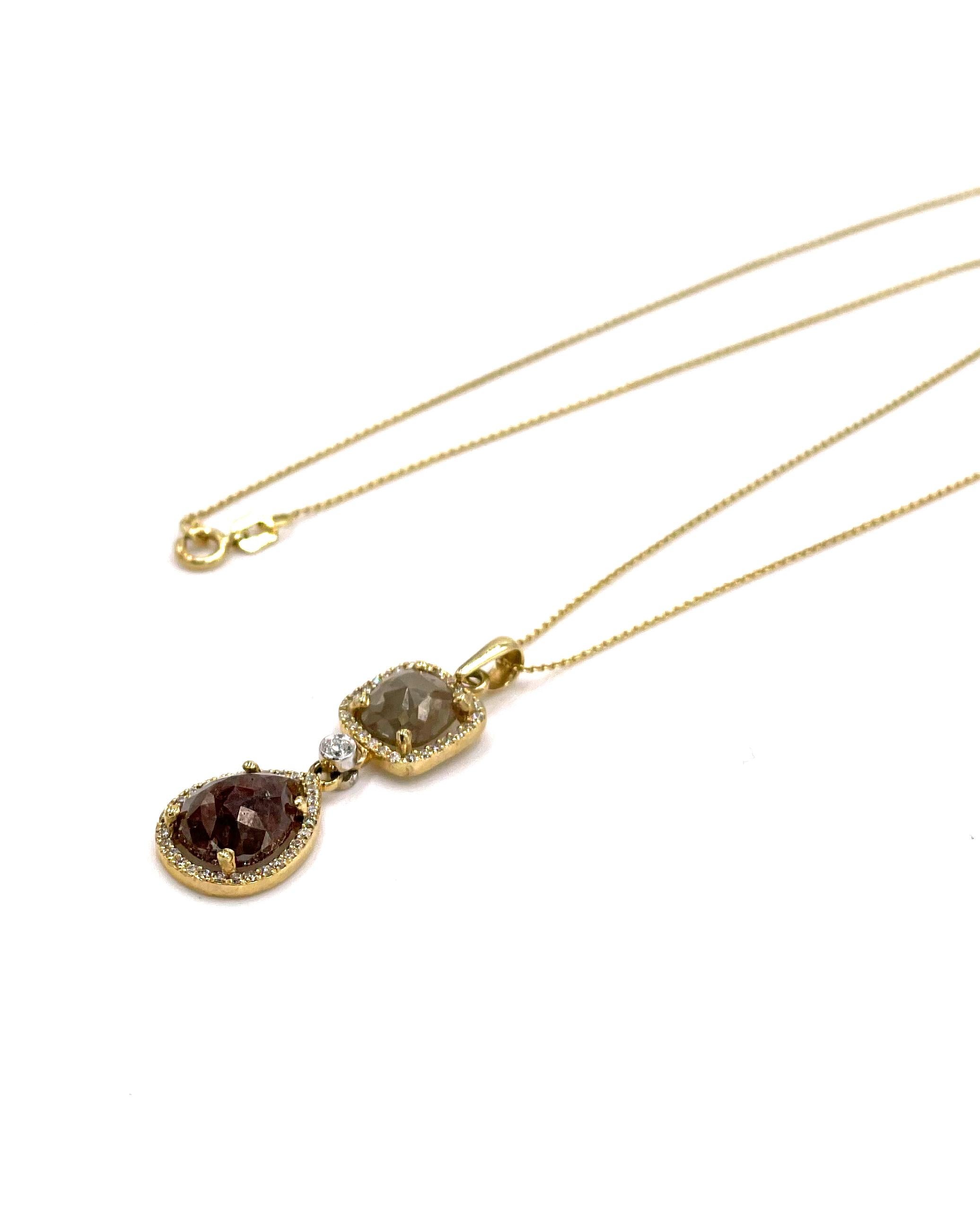 14K yellow gold necklace with one light brown rough cut chocolate diamond and one darker brown pear shape rough cut chocolate diamond.  The brown diamonds are embellished with a halo of round white diamonds.  The pendant slides on a 18 inch cable