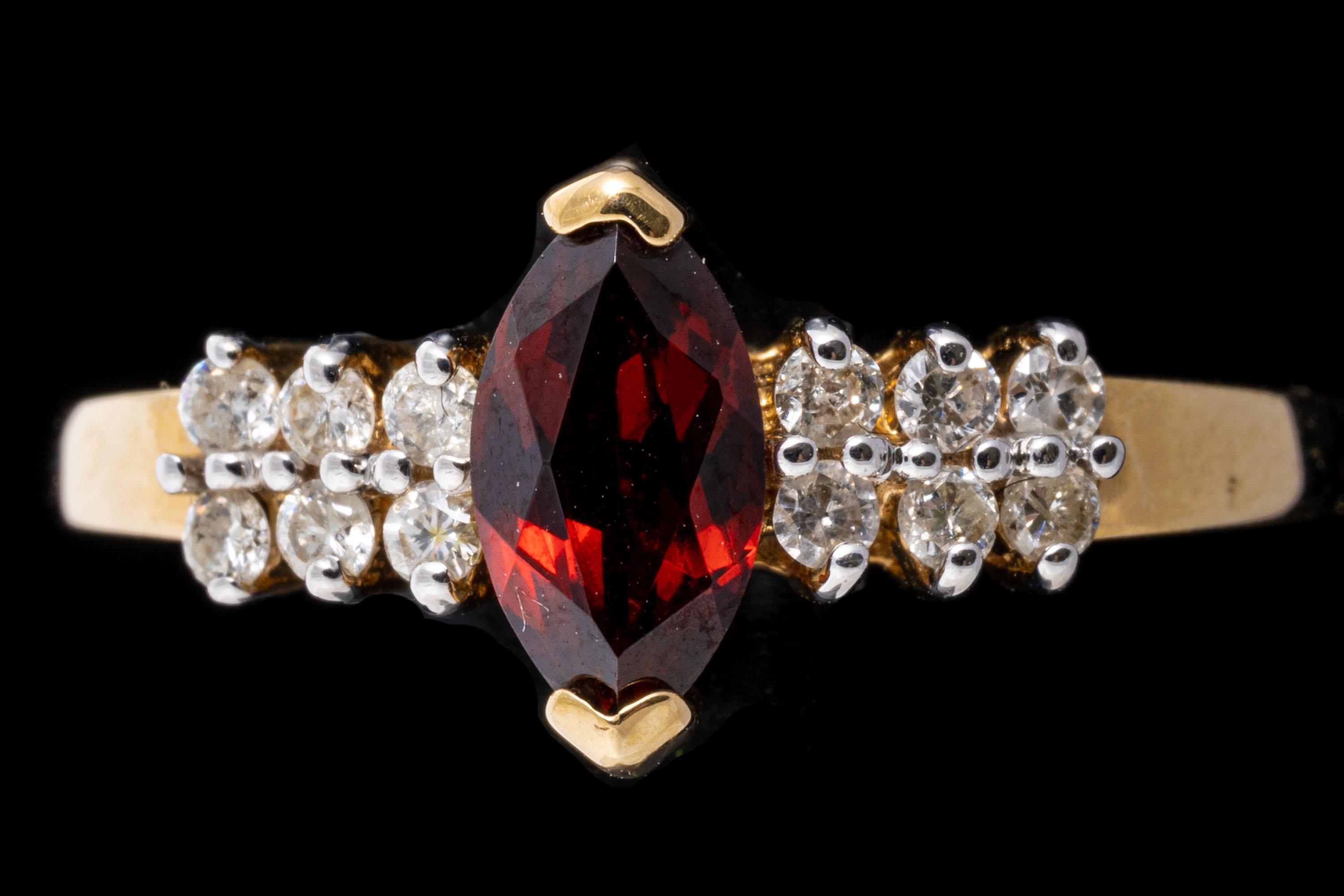 14k yellow gold ring. This classic ring has a marquise faceted shaped center, dark burgundy color, approximately 0.45 CTS, flanked by two rows of round faceted diamonds, approximately 0.12 TCW. All of the stones are prong set.
Marks: 14k