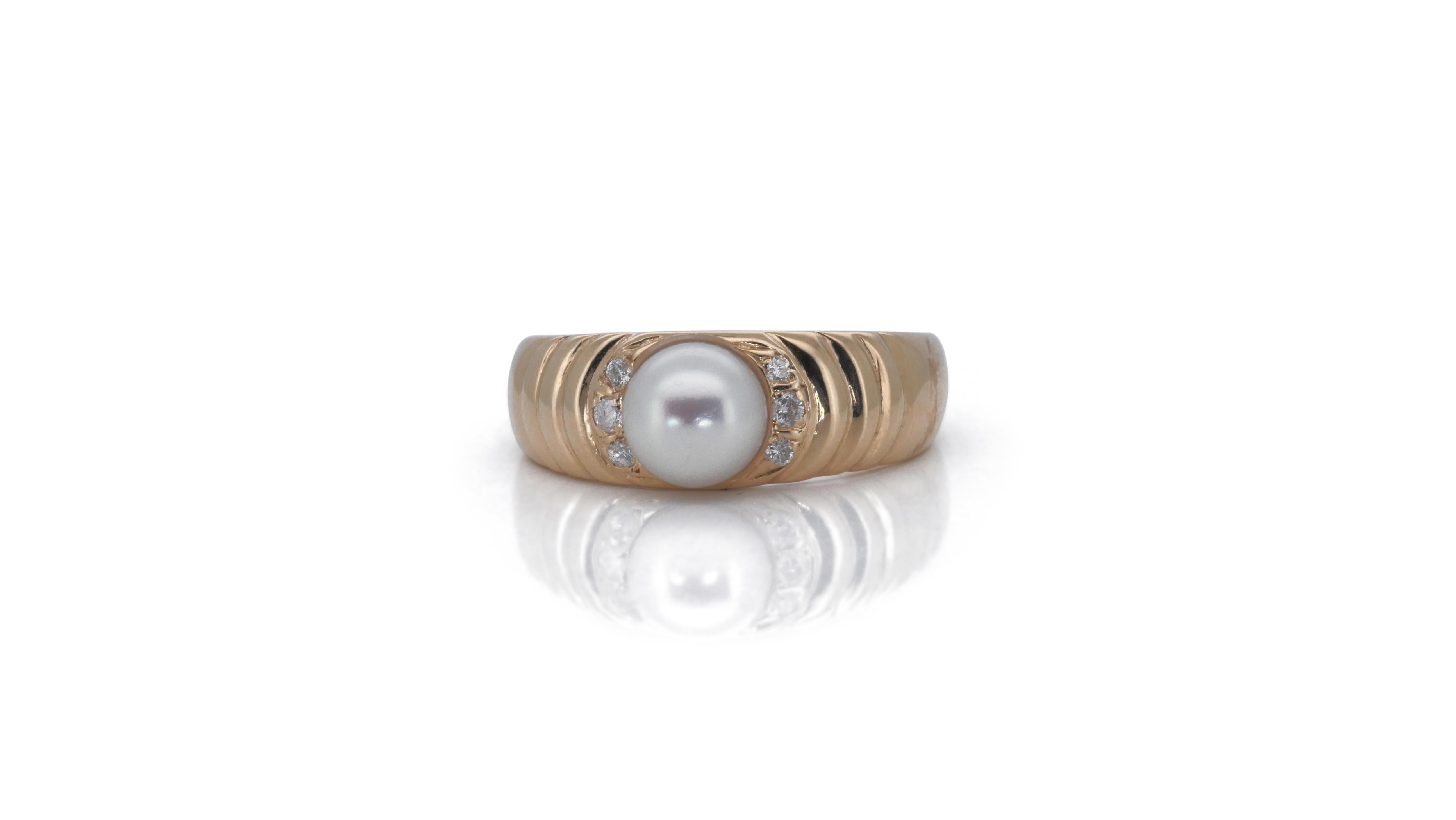 Ein wunderschöner Clusterring mit einer schillernden 1-karätigen runden Brillant-Naturperle. Er hat 0.06 Karat seitliche Diamanten, die seine Eleganz noch unterstreichen. Das Schmuckstück ist aus 14k Gelbgold mit einer hochwertigen Politur