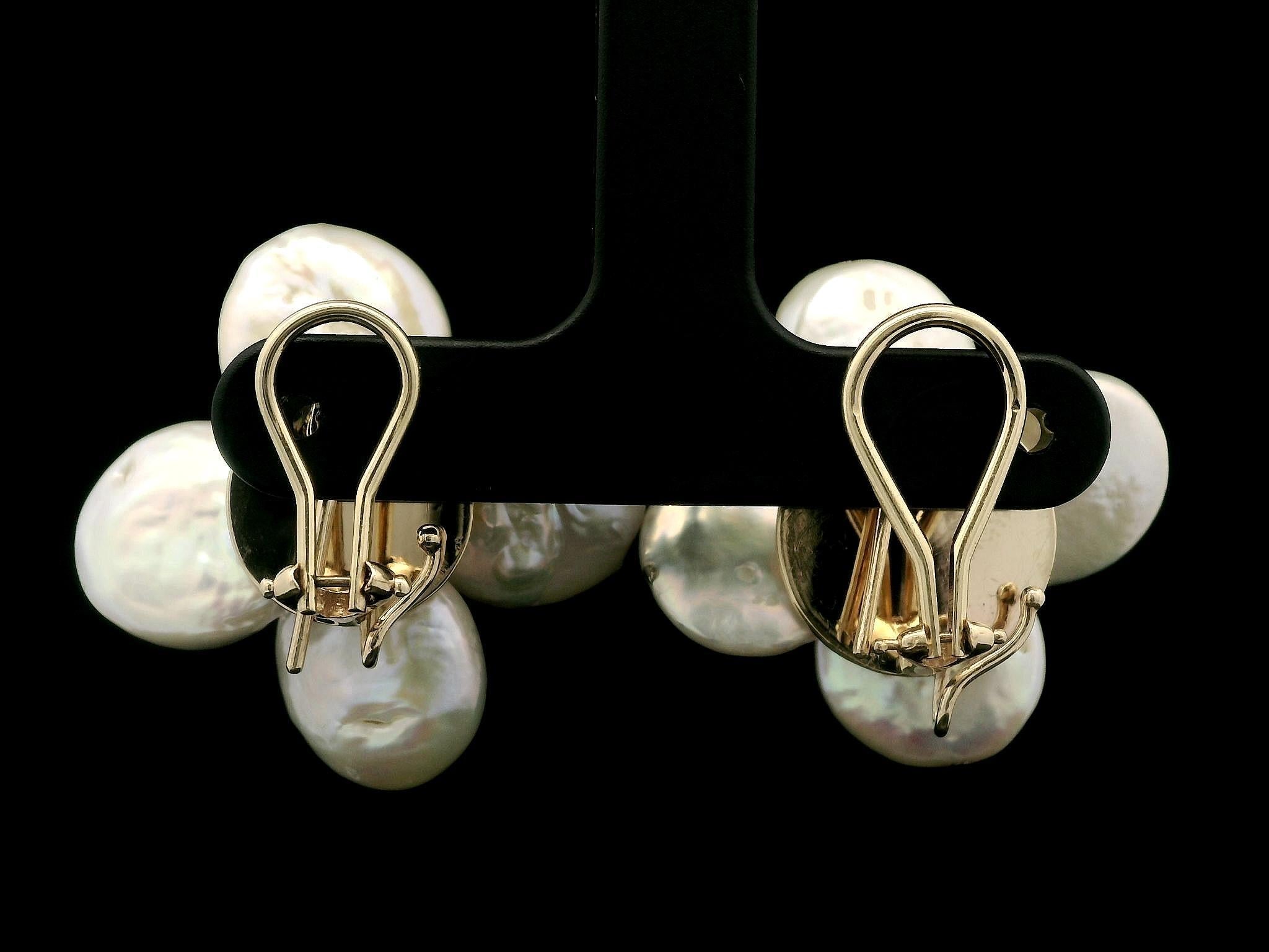 -- Stone(s) --
(8) Genuine Coin Pearls - Baroque Shape - White Color w/ Slight Pink Overtone - 12.62 x 12.91mm (approx.)
(2) Natural Genuine Amethyst - Round Cut - Medium Purple Color - 6.36mm (approx.)

Material: 14K Yellow Gold
Weight: 15.50
