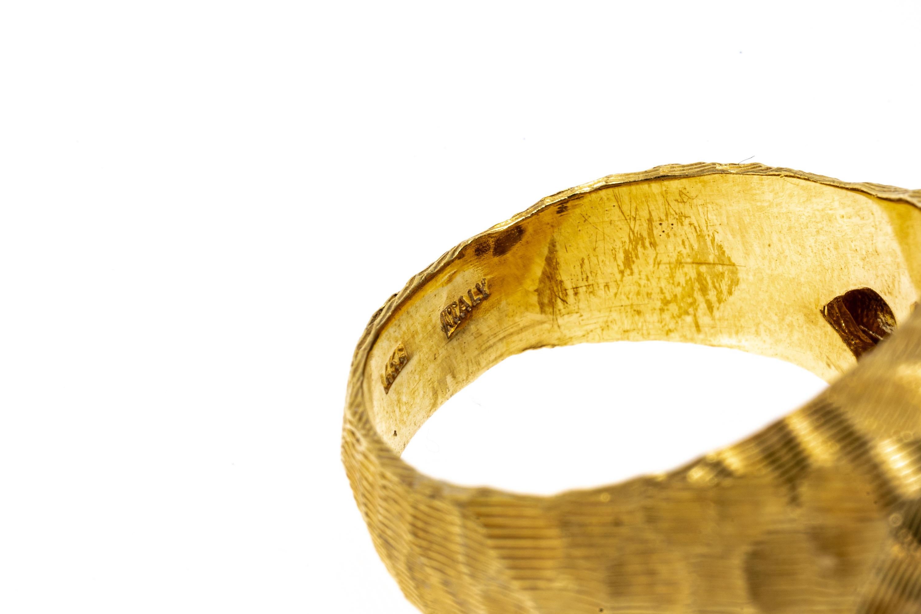 14k yellow gold ring. This unusual yellow gold ring is a free form, slightly concave profile, with a hammered style patterning and decorated with a fine, grooved pattern throughout, including the shoulders and shank.
Marks: 14k
Dimensions: 3/4