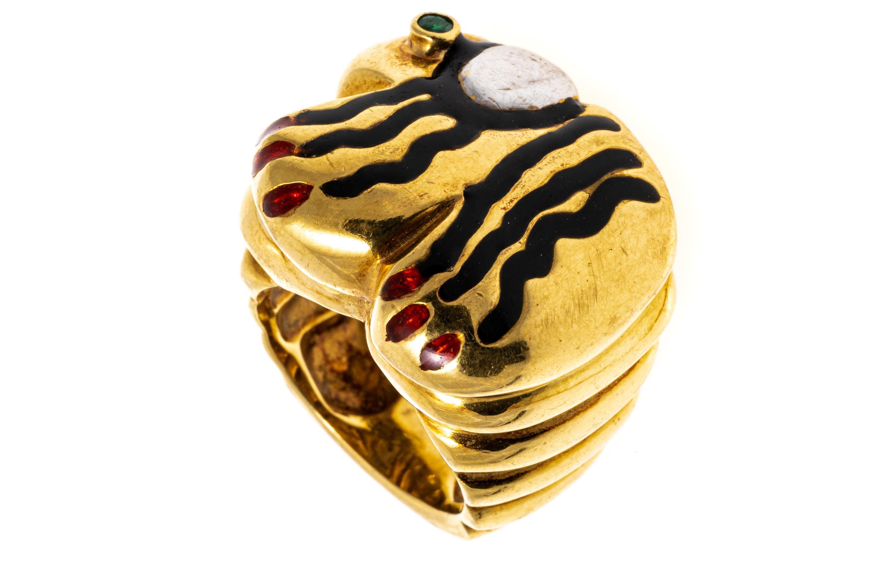 14k yellow gold ring. This funky dome ring has a quirky animal top, with a squiggled black enamel body, red enamel toes and a round faceted, medium green color emerald eye, approximately 0.04 CTS, bezel set.
Marks: Tested 14k
Dimensions: 1