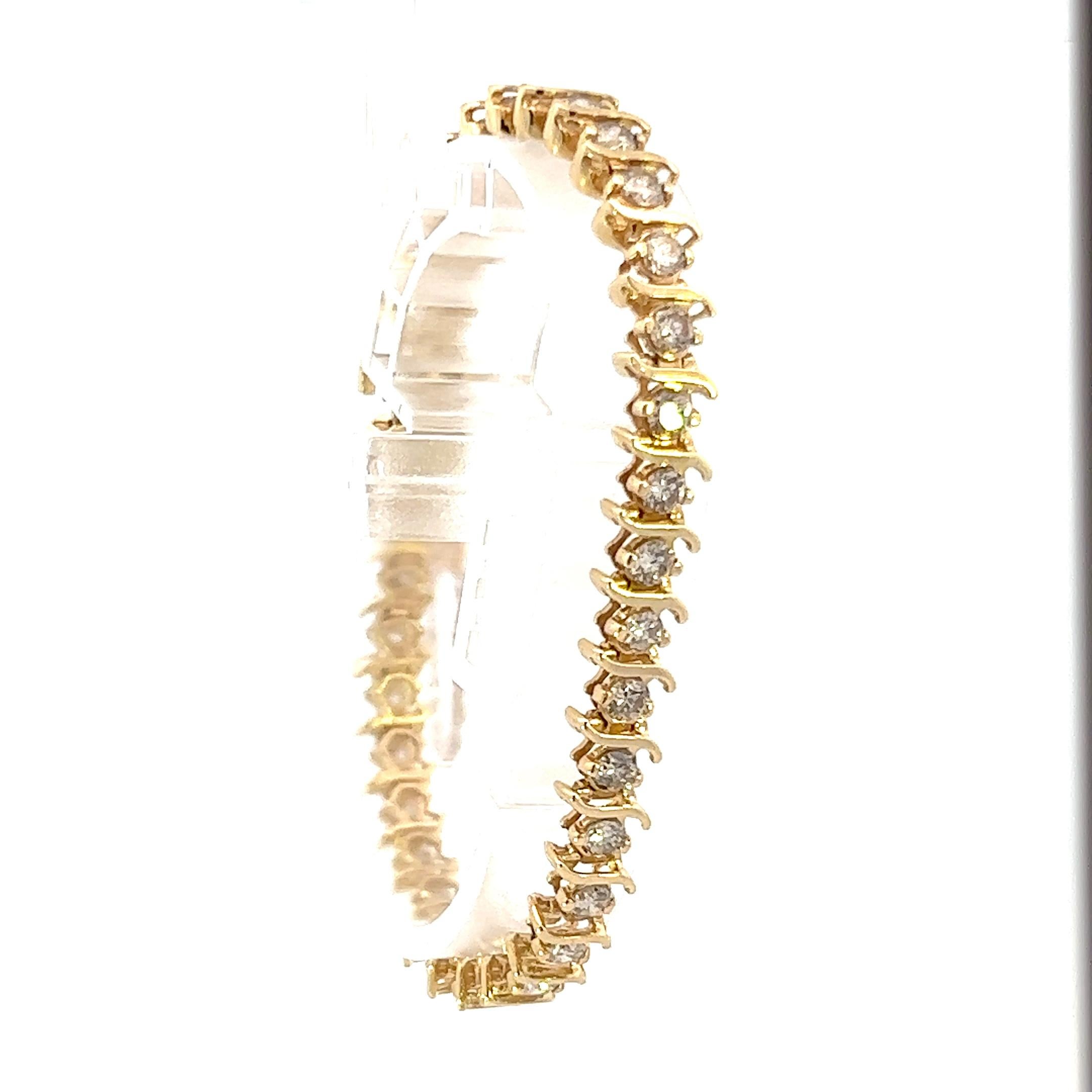 This is a unique 14k yellow gold contemporary diamond bracelet. Being made in 14k yellow gold, this bracelet displays a rich tone and offers timeless appeal. Although this 14k yellow gold bracelet has a classic appeal, it also has a distinctive look