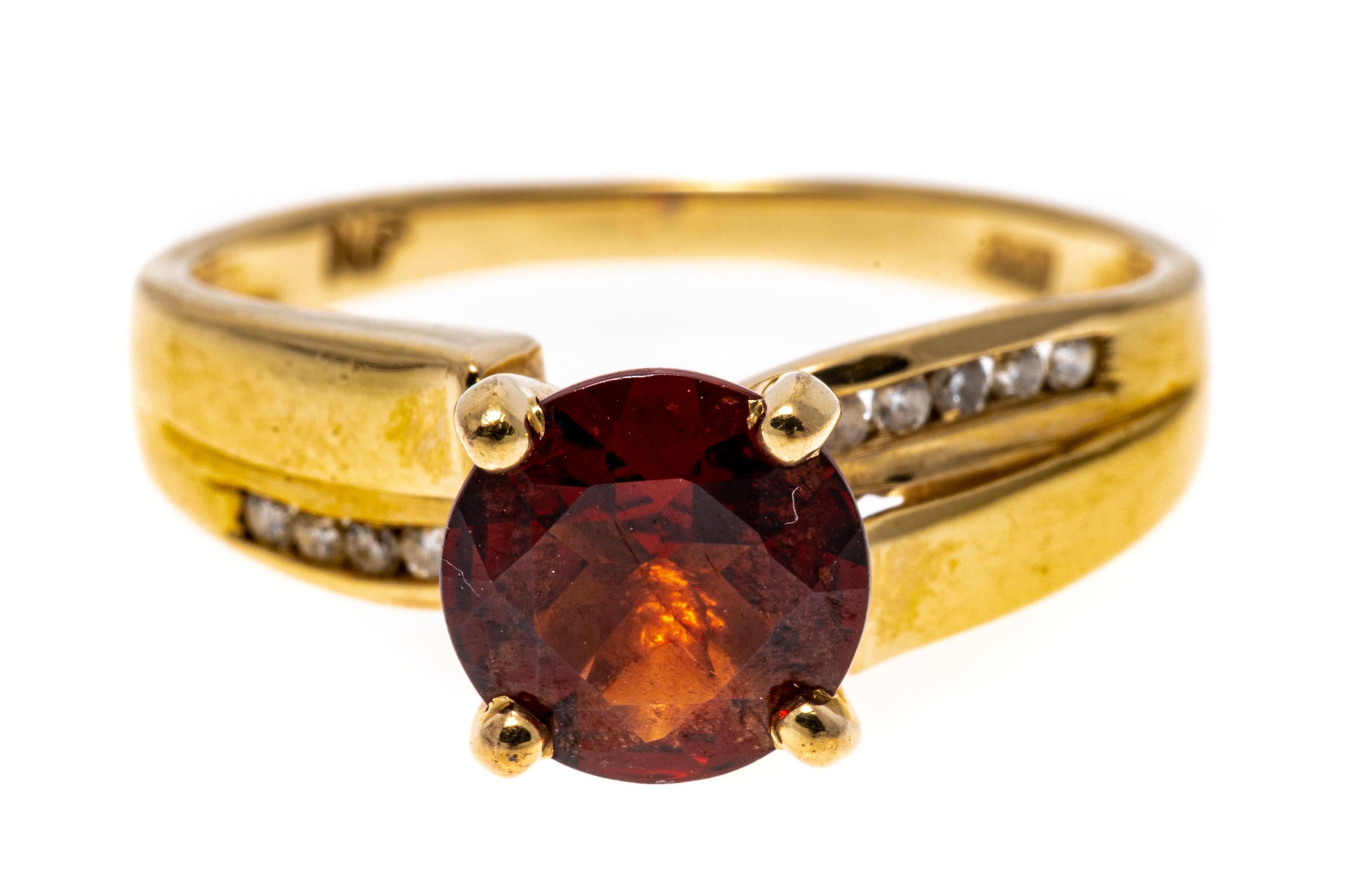 14k yellow gold ring. 14k yellow gold handsome round faceted burgundy color garnet, approximately 0.86 CTS, prong set and decorated with offset, channel set round faceted diamond sides, approximately 0.05 TCW.
Marks: 14k
Dimensions: 5/8
