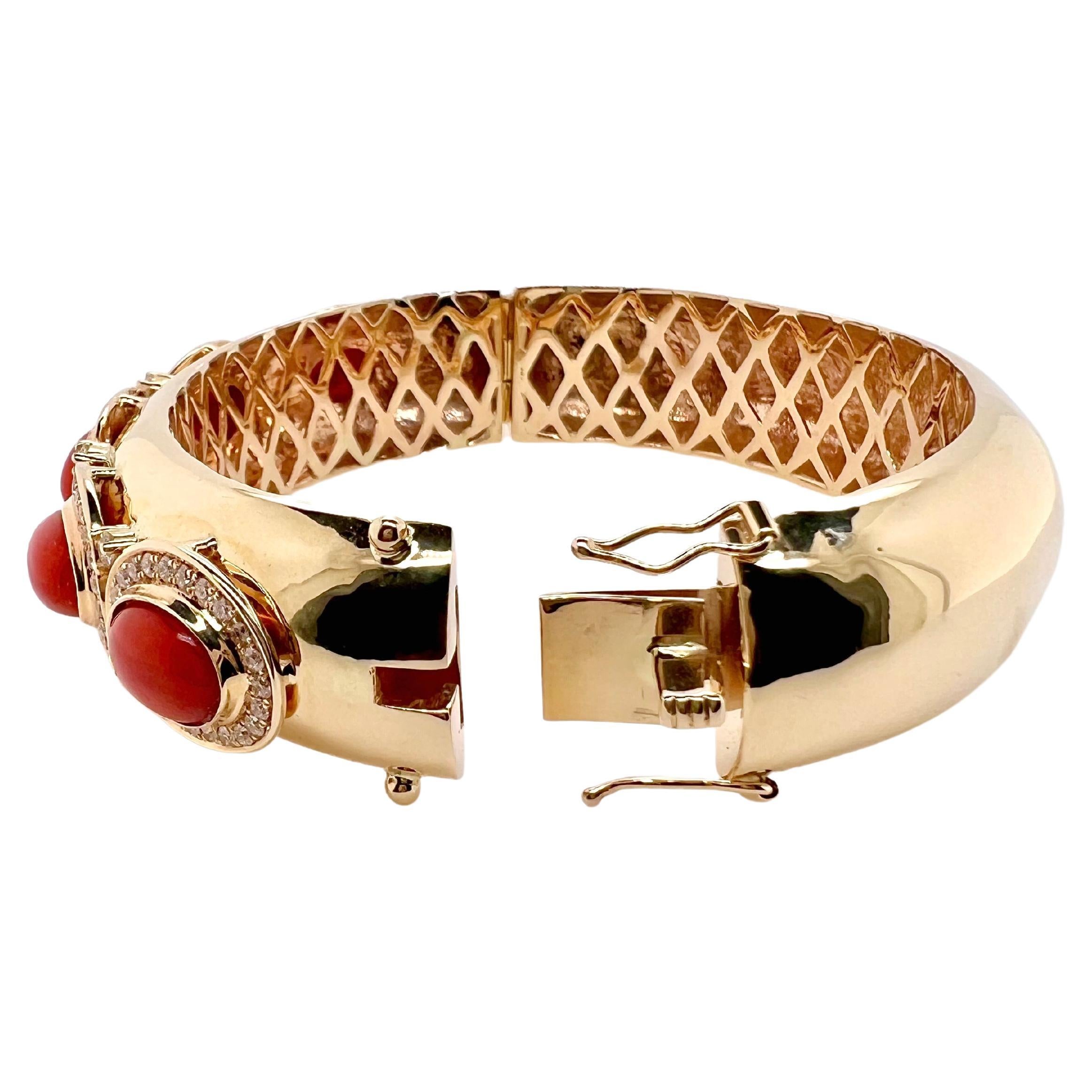 This stunning bangle is handmade with meticulous details.  The coral cabochons are bezel set with round brilliant diamonds surrounding it.  The vibrant coral stands out against the yellow gold and the bangle has an underneath gallery to finish off