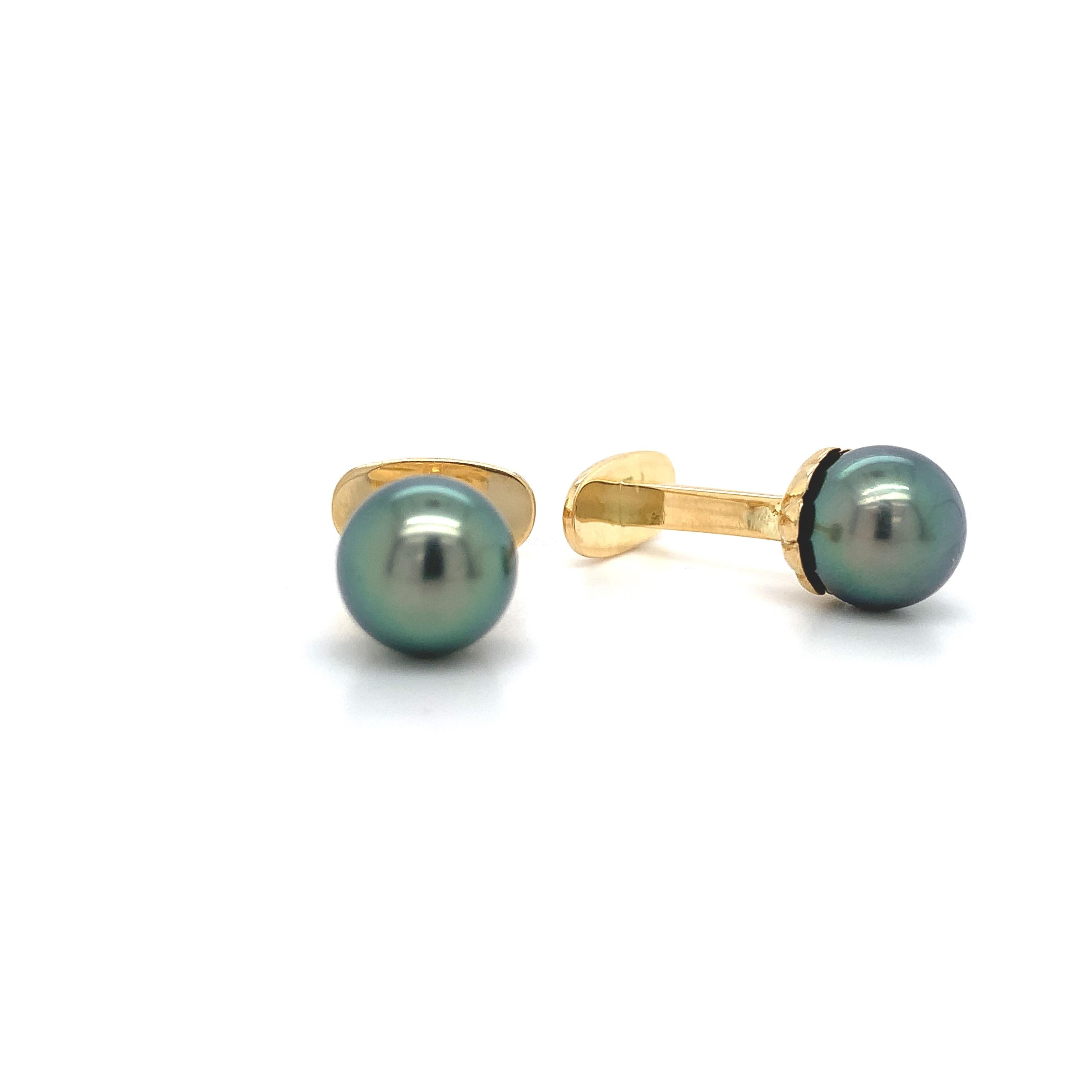A pair of 14K yellow gold cufflinks featuring large Tahitian black cultured Pearls. The pearls are completely round, are free from blemishes, and have a peacock natural color. The Pearls measure 9mm.  The pair weighs 4.72dwt and custom, newly made.