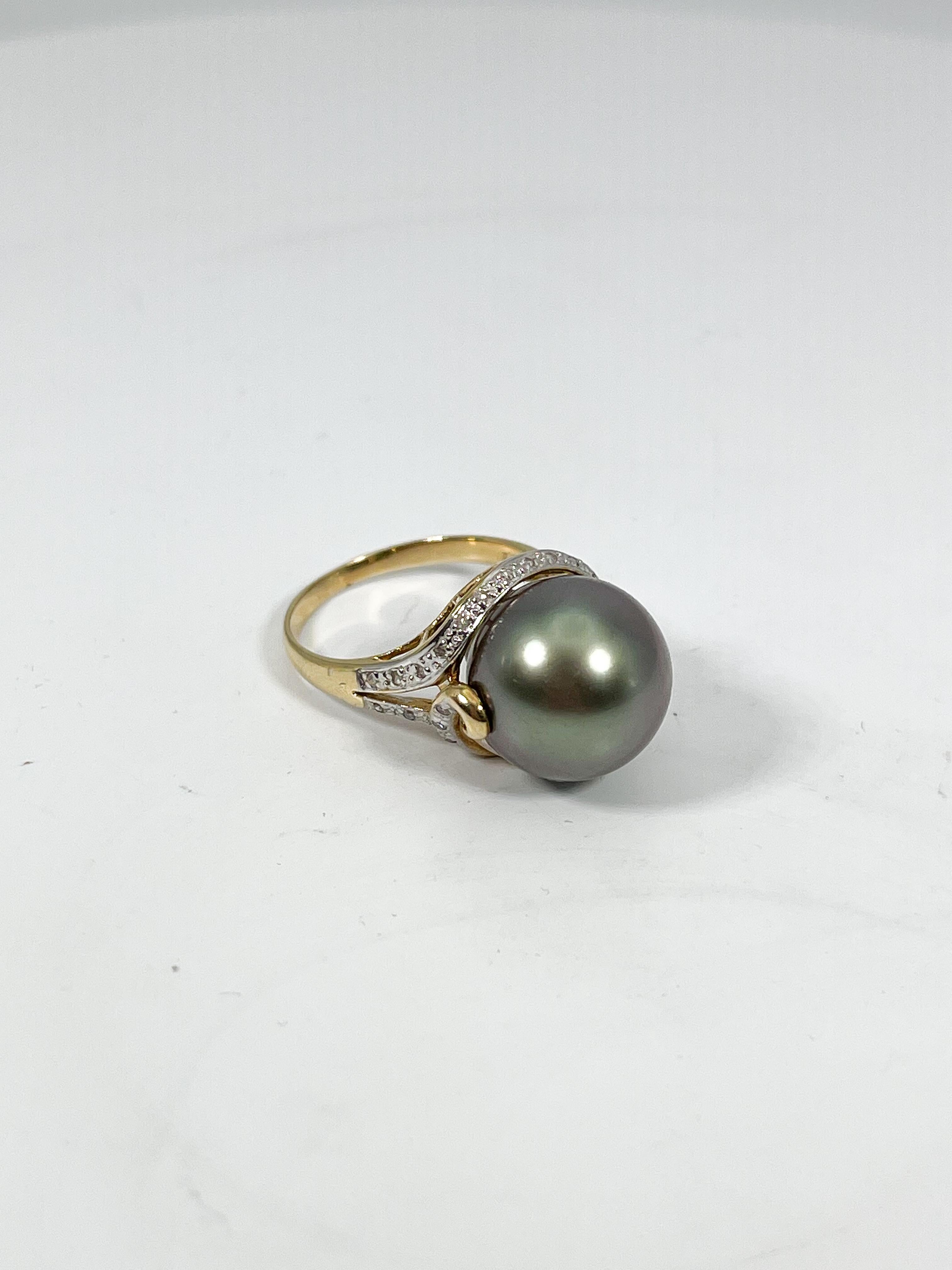 14k yellow gold cultured black pearl and diamond ring. This ring has round diamonds along the sides of the ring, the width of the pearl is 13 mm, the size of the ring is a 6 1/2, and it has a total weight of 6.36 grams.