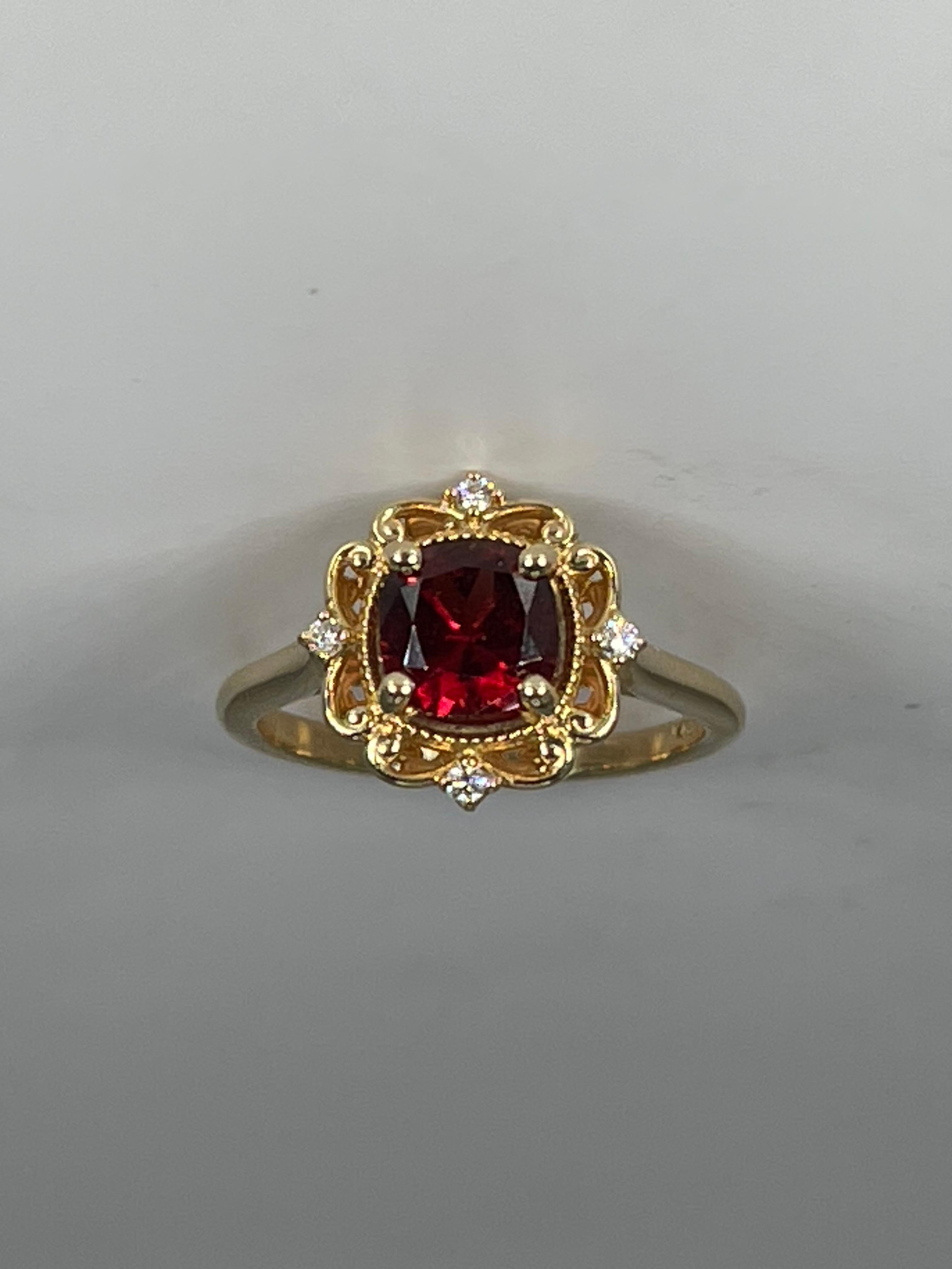 14k yellow gold cushion 1.40 CTW cut spinel with diamonds. The ring has scrolling detail around the gemstone along with 4 diamonds on the top, bottom, and sides of the stone. The stone measures 6.3 x 6.3 and the ring has a total weight of 3.97 grams.