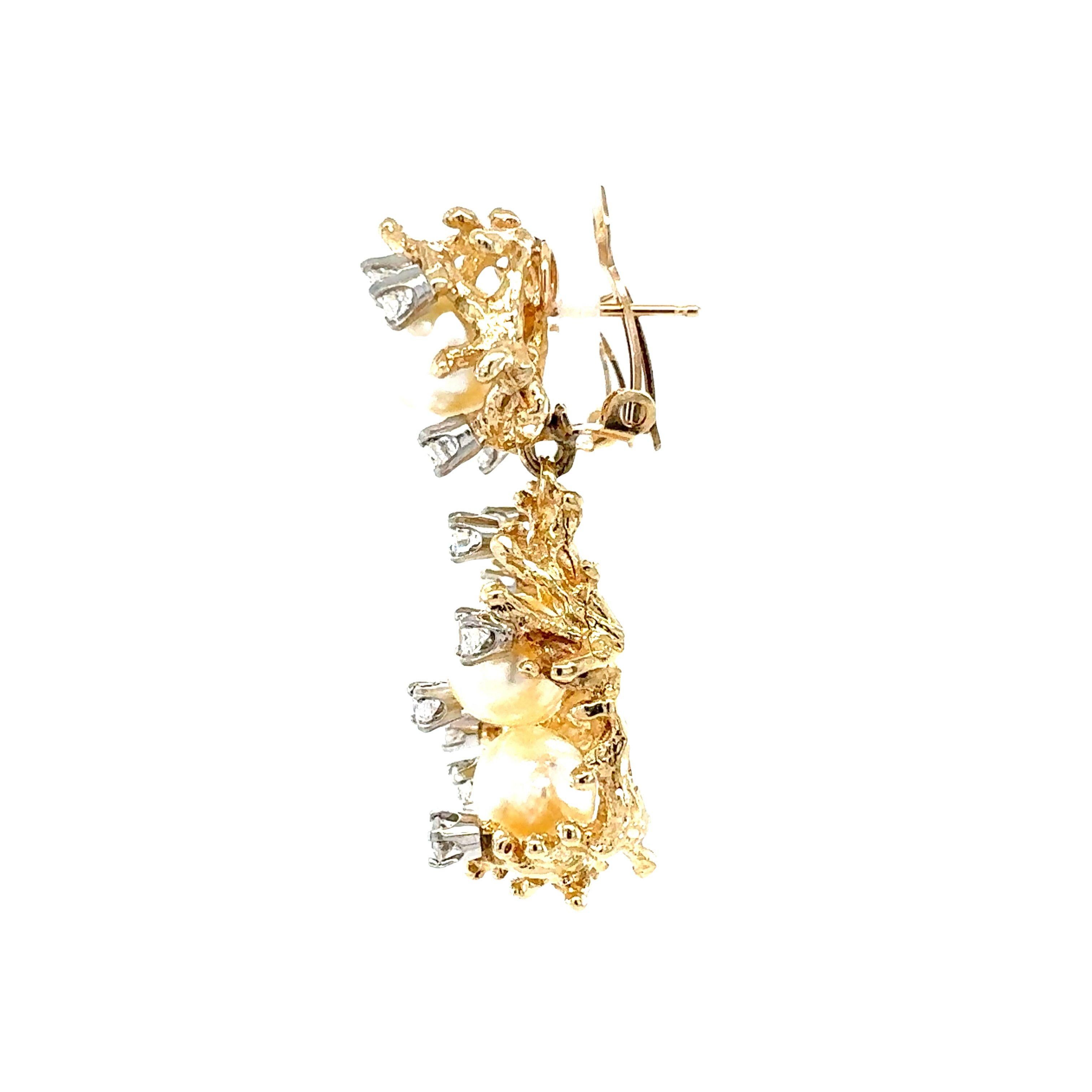This elegant pair of 14K yellow gold dangle earrings from the 1970s features a harmonious blend of pearls and diamonds, embodying timeless sophistication. Each earring showcases four round, cream-colored cultured pearls, measuring 8 mm in diameter,