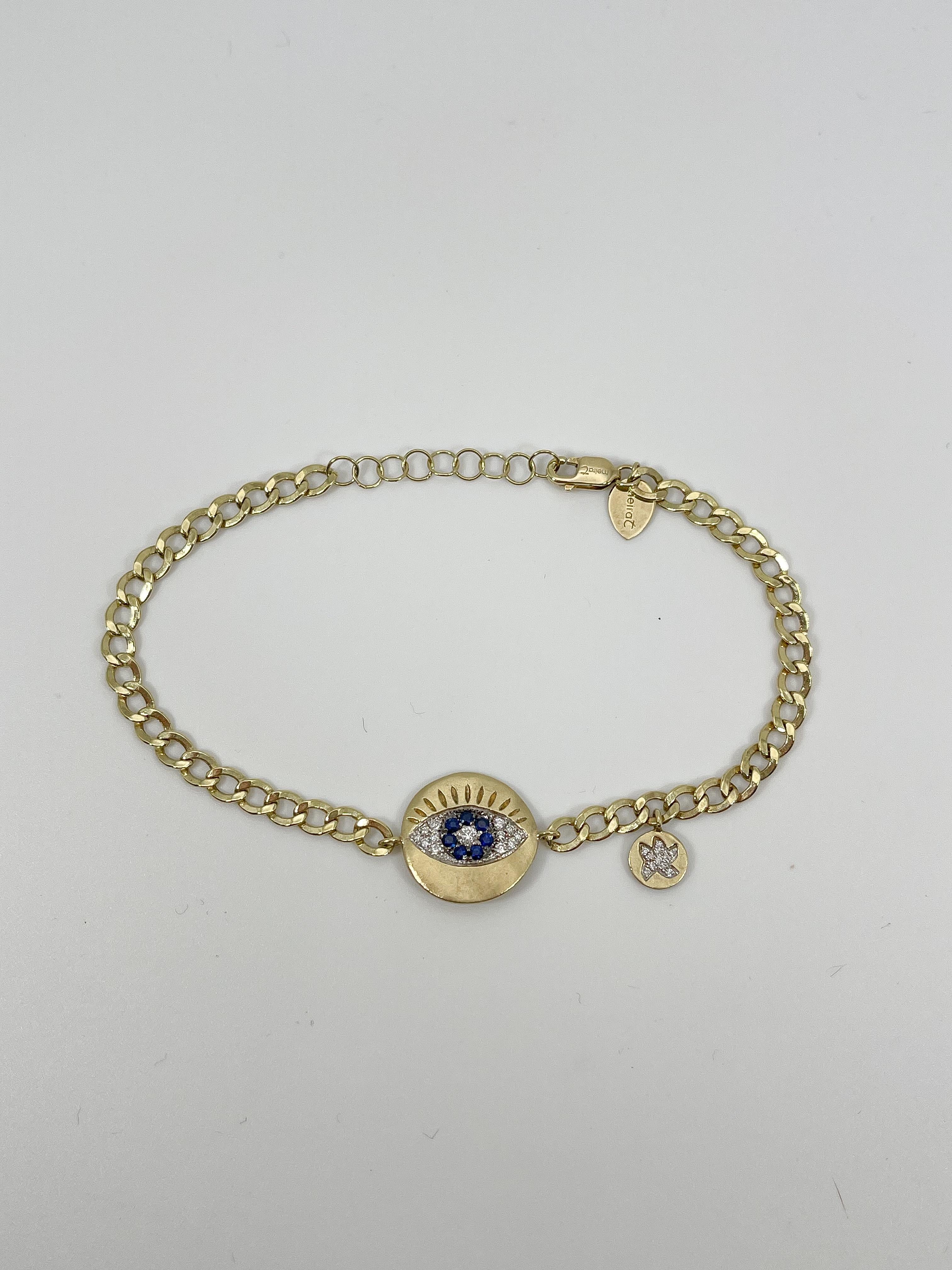 14k yellow gold diamond and sapphire evil eye bracelet. All stones in this bracelet are round, the evil eye measures to be 13.5mm in diameter, bracelet has a stationed charm with diamonds to the side of the evil eye, the bracelet measures to be 7
