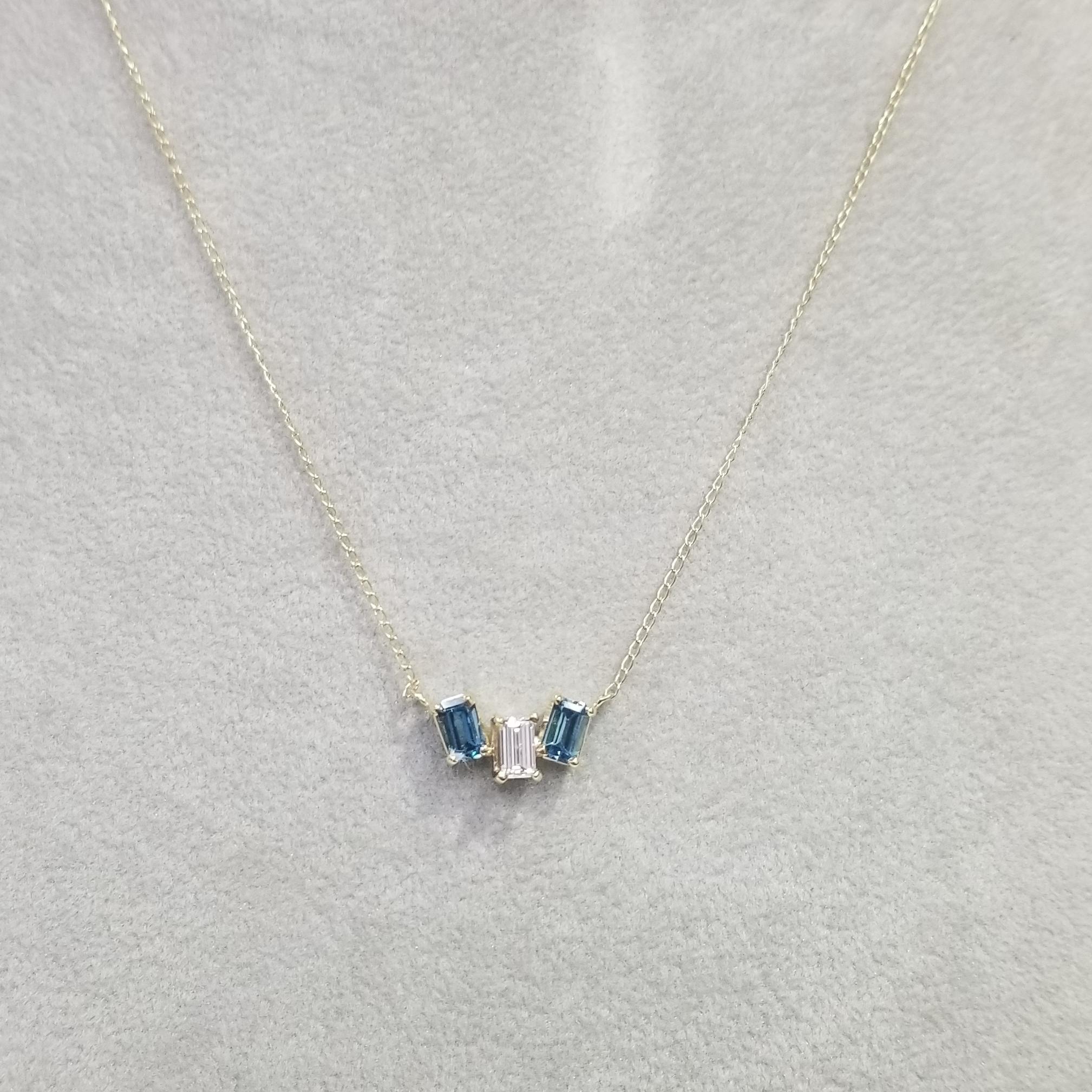 14k yellow gold diamond baguette and blue topaz pendant, with 1 diamond baguette cut weighing .35pts. and 2 topaz baguettes weighing .70pts. on a 14.5 inch chain.